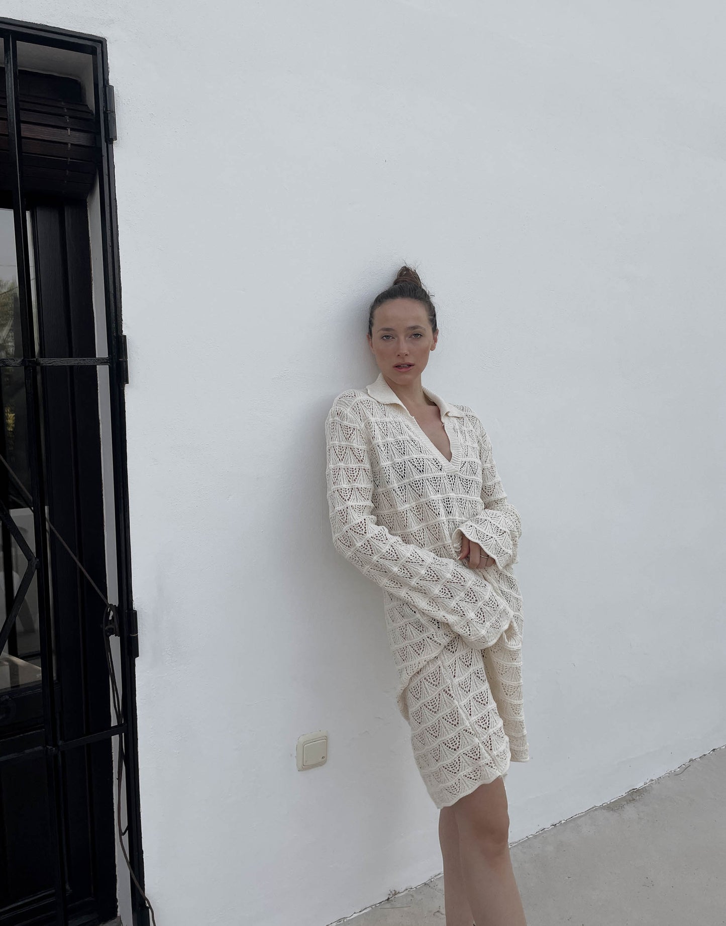 Frau mit brauen Haaren trägt Midi Häkelkleid in beige