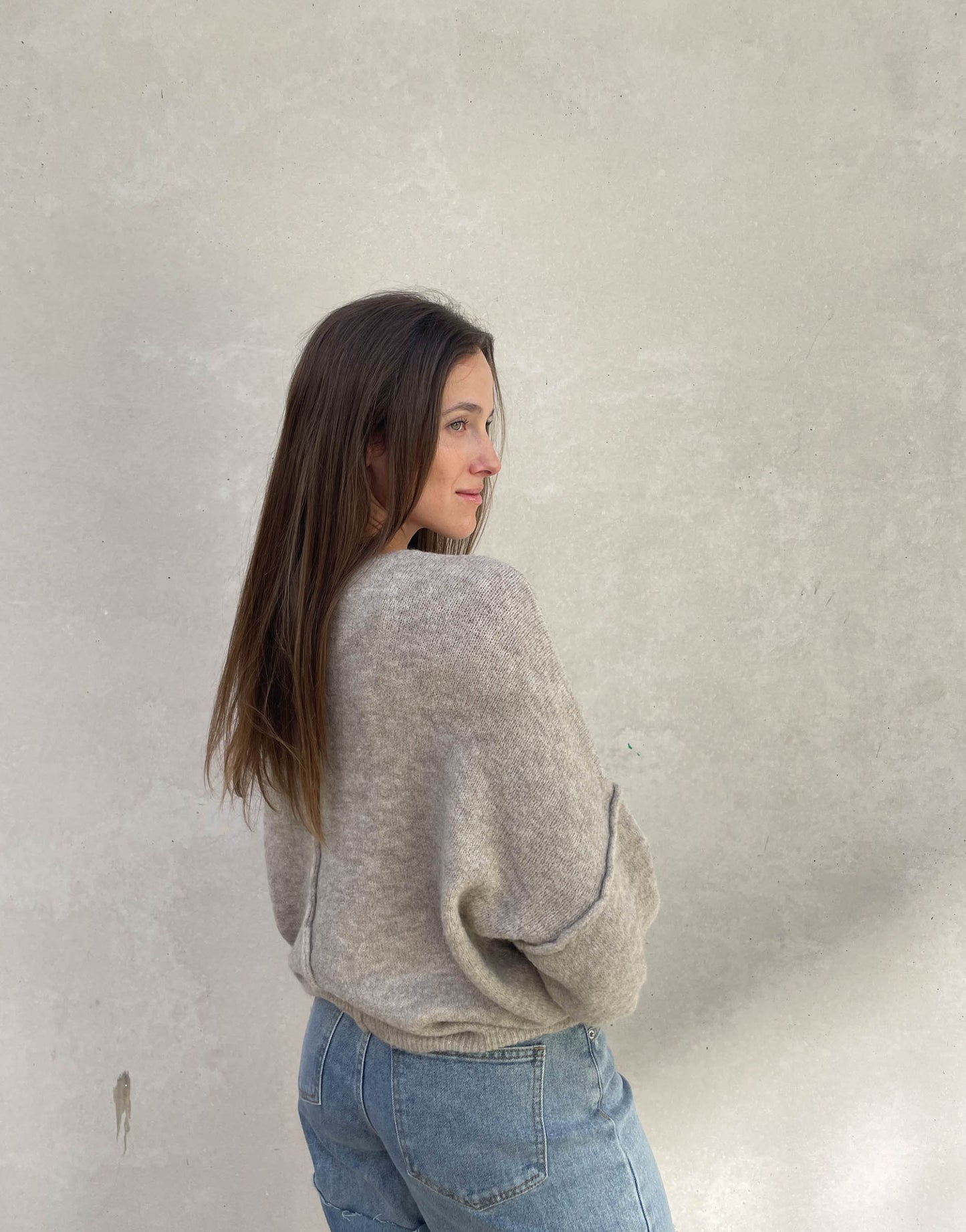Frau mit brauen Haaren trägt Pullover mit Außennaht in Taupe 04