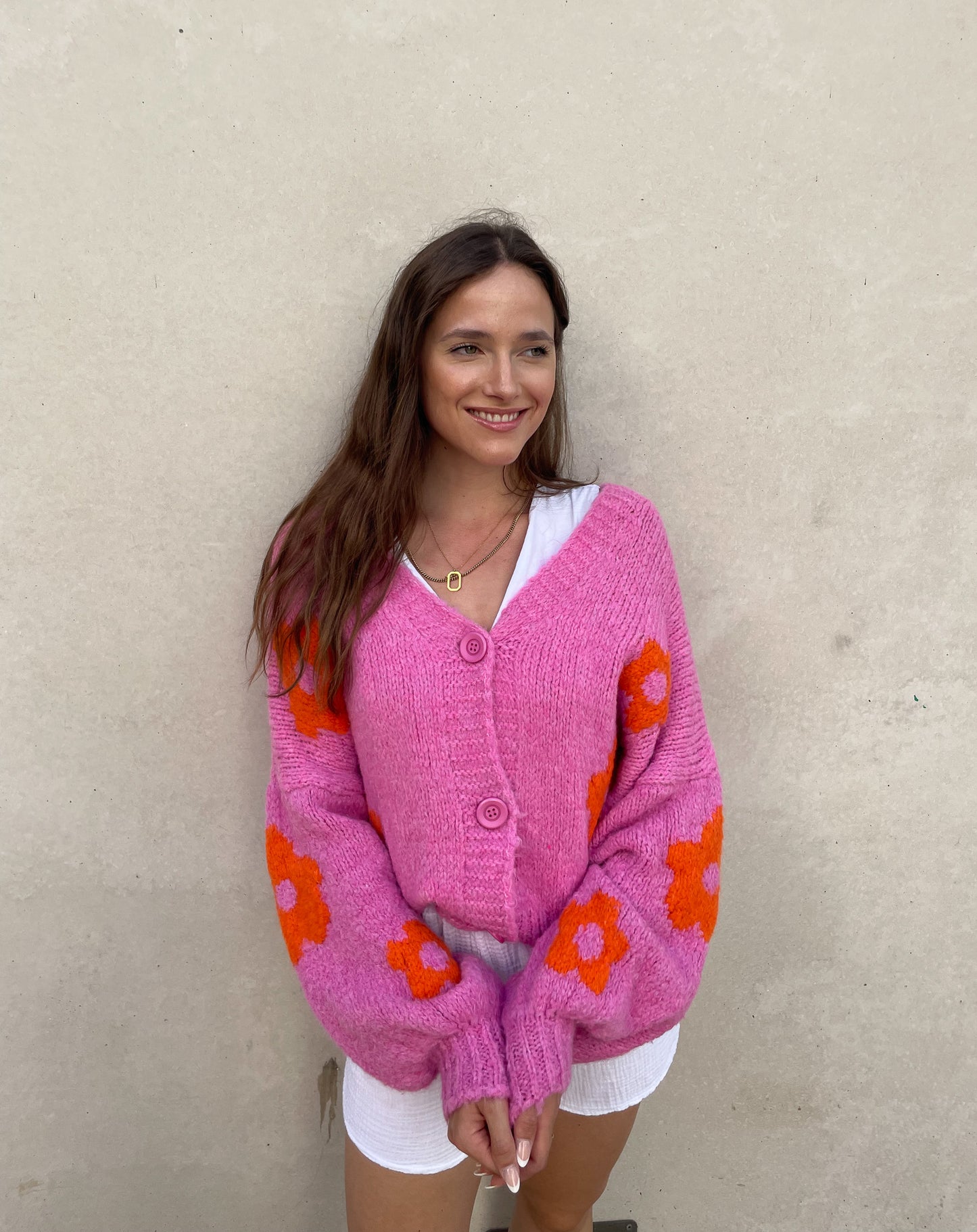 Frau mit brauen Haaren trägt Strickjacke mit Blumenprint
