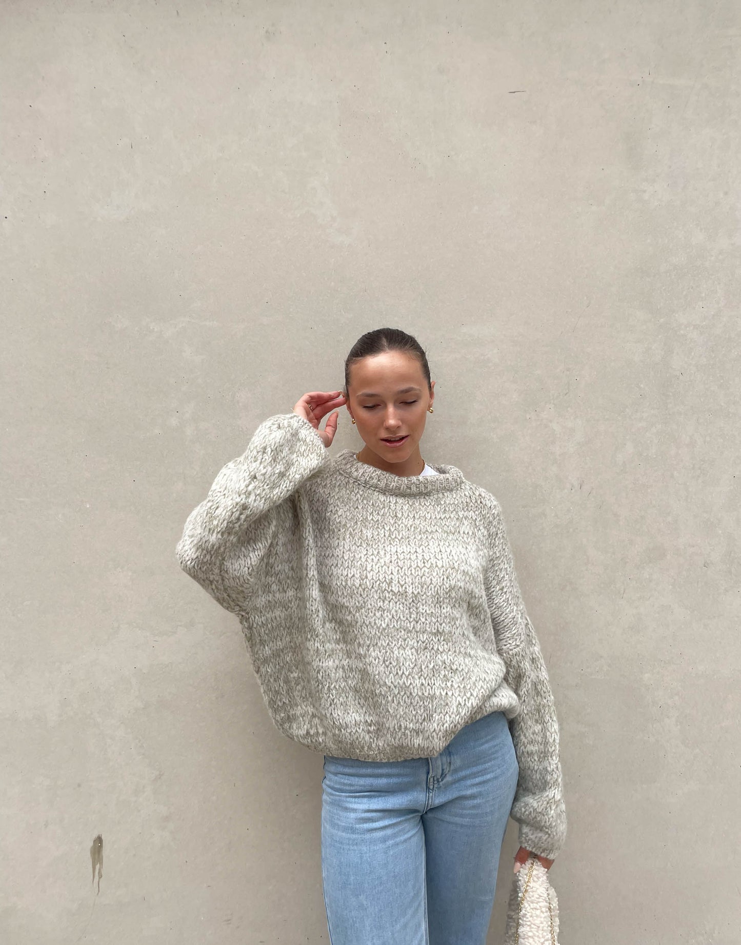 Frau mit brauen Haaren trägt weiten Strickpullover in Mint