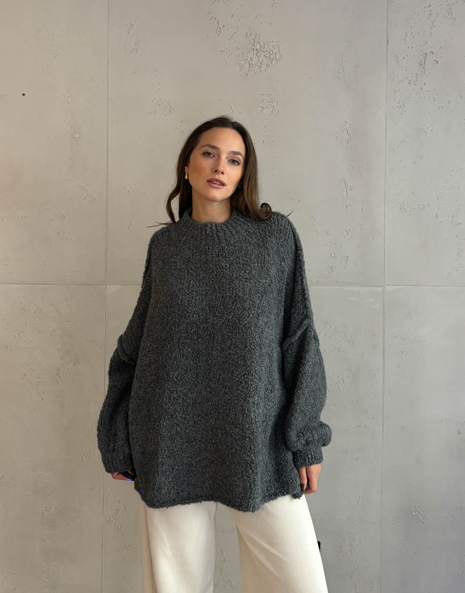 Frau mit braunen haaren trägt Oversize Stehkragen Pullover in Boucle