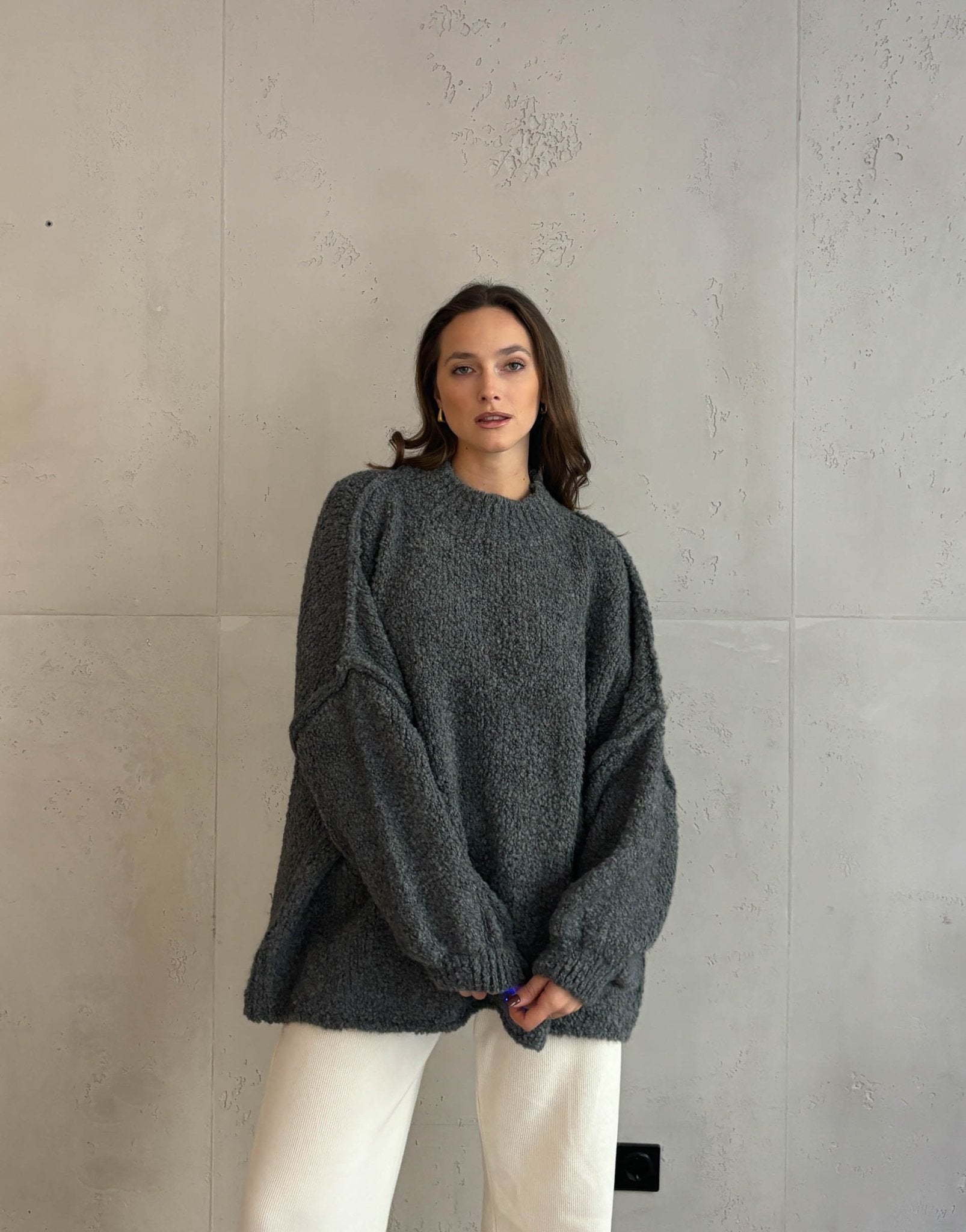 Frau mit braunen haaren trägt Oversize Stehkragen Pullover in Boucle