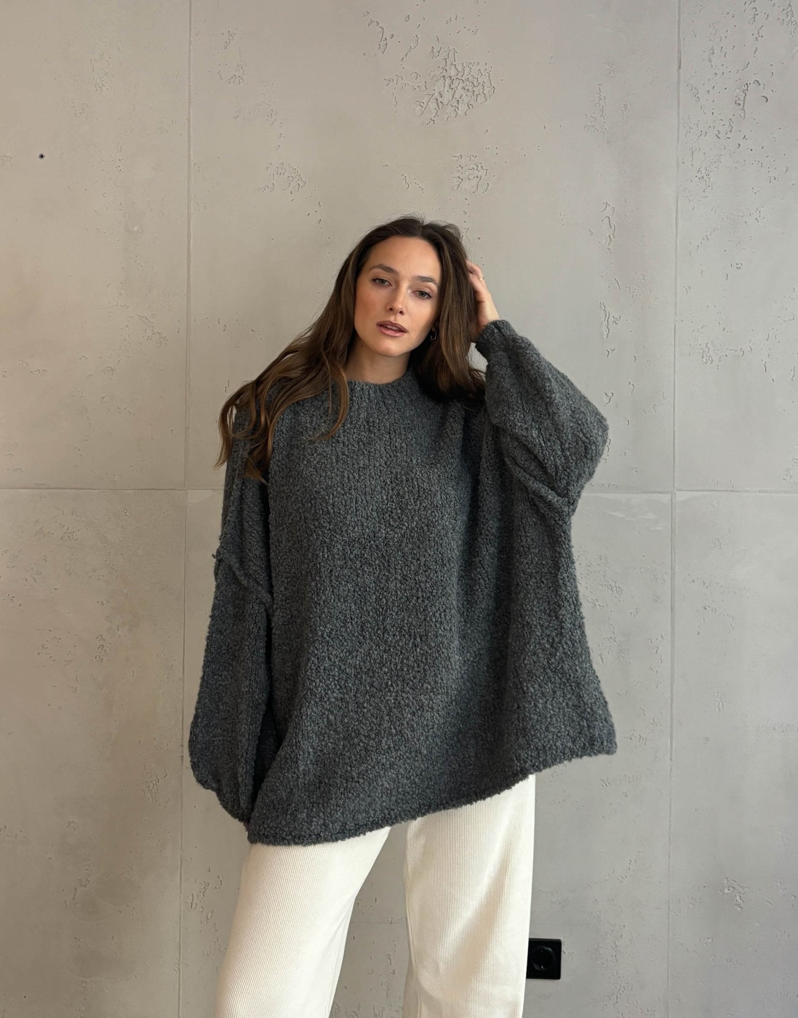 Frau mit braunen haaren trägt Oversize Stehkragen Pullover in Boucle