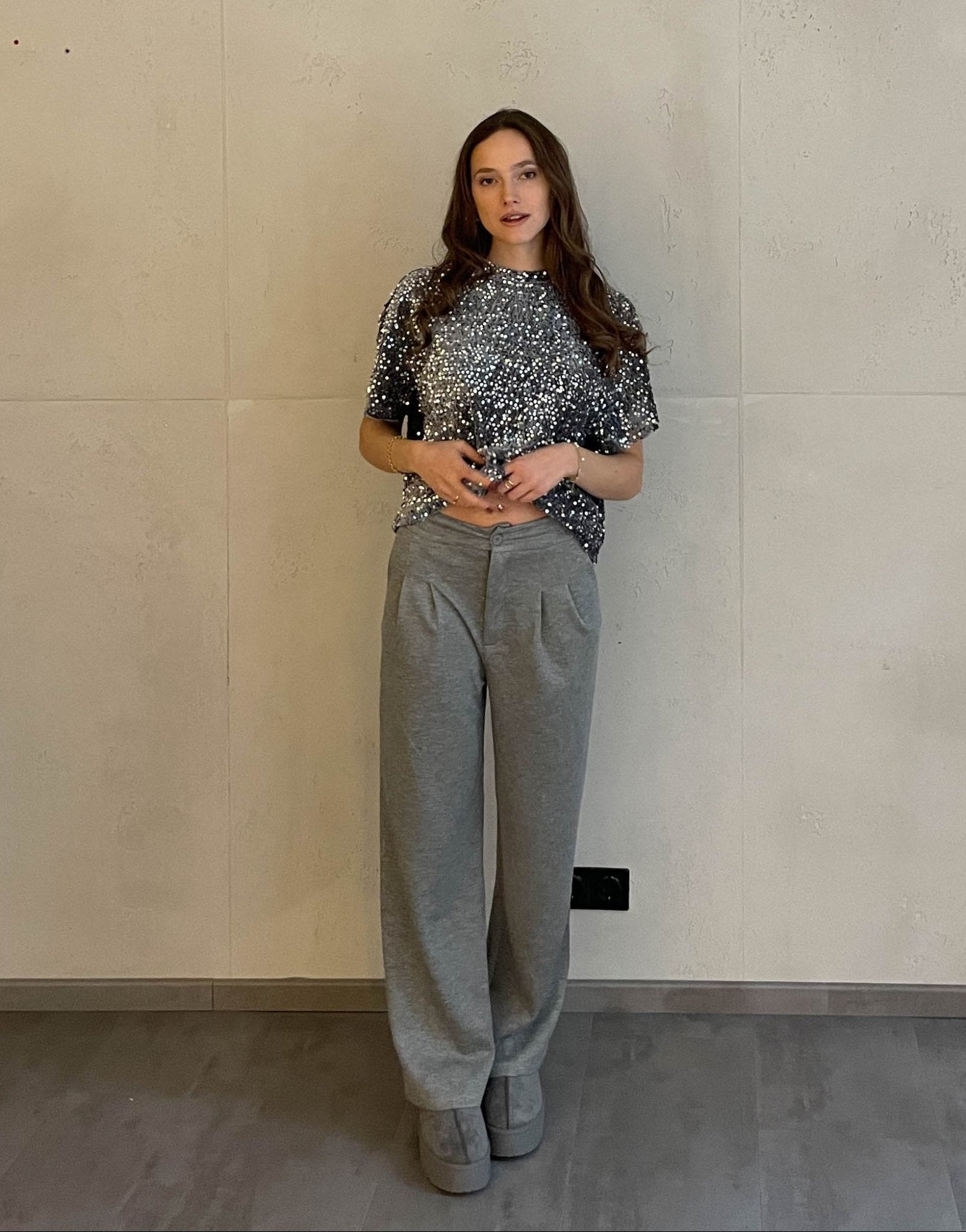 Frau mit braunen Haaren trägt Anzughose in Grau