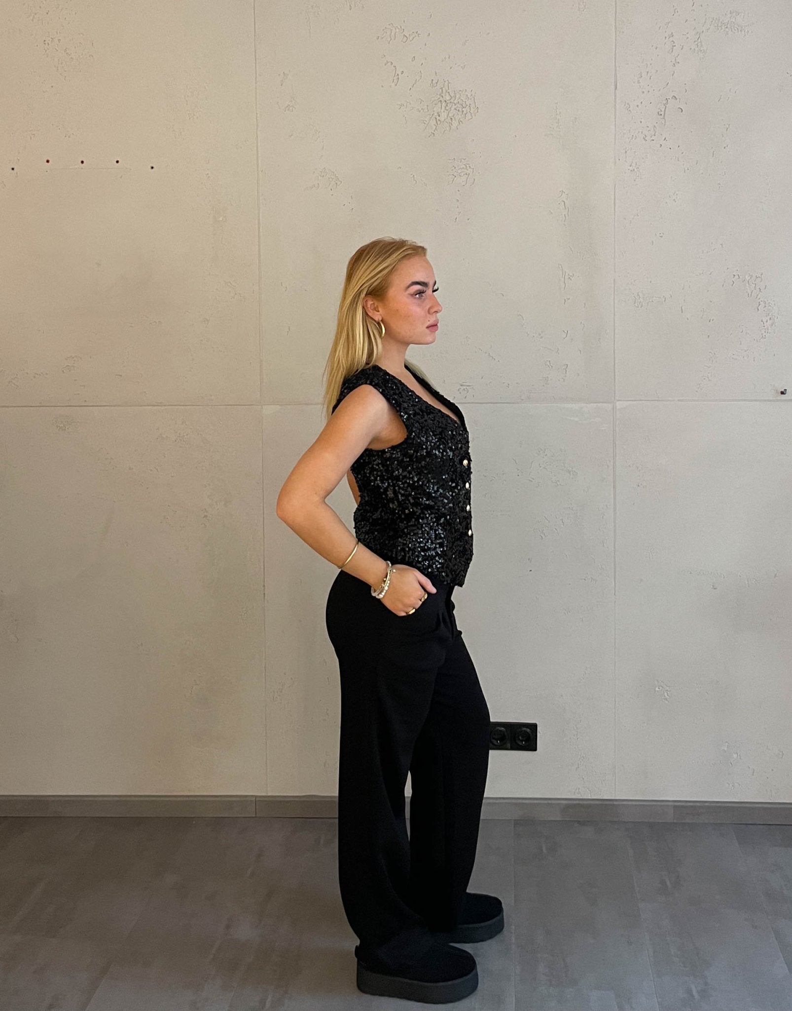 Frau mit blonden Haaren trägt Anzughose in Schwarz