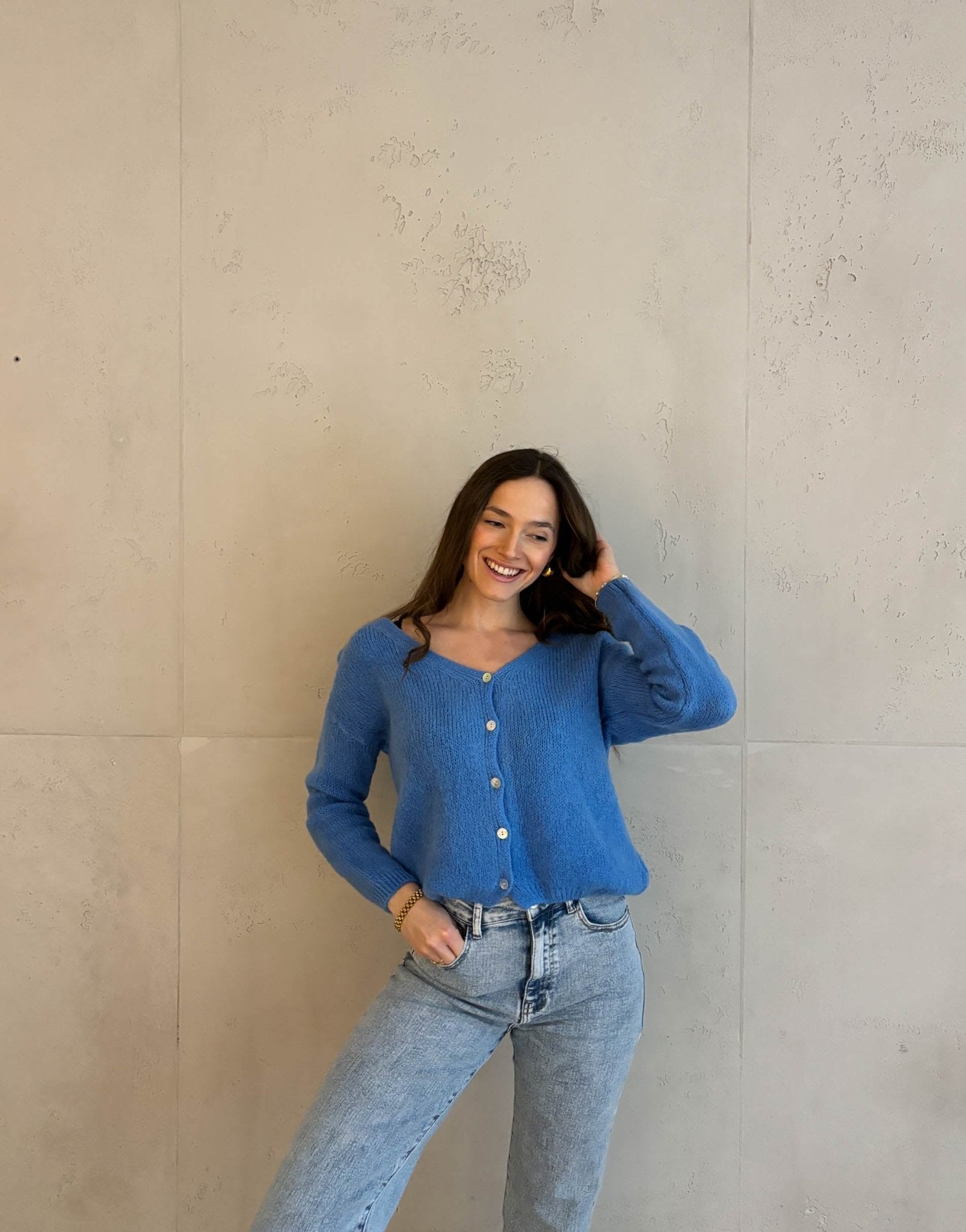 Frau mit brauen Haaren trägt kurze Mohair Strickjacke in Royalblau