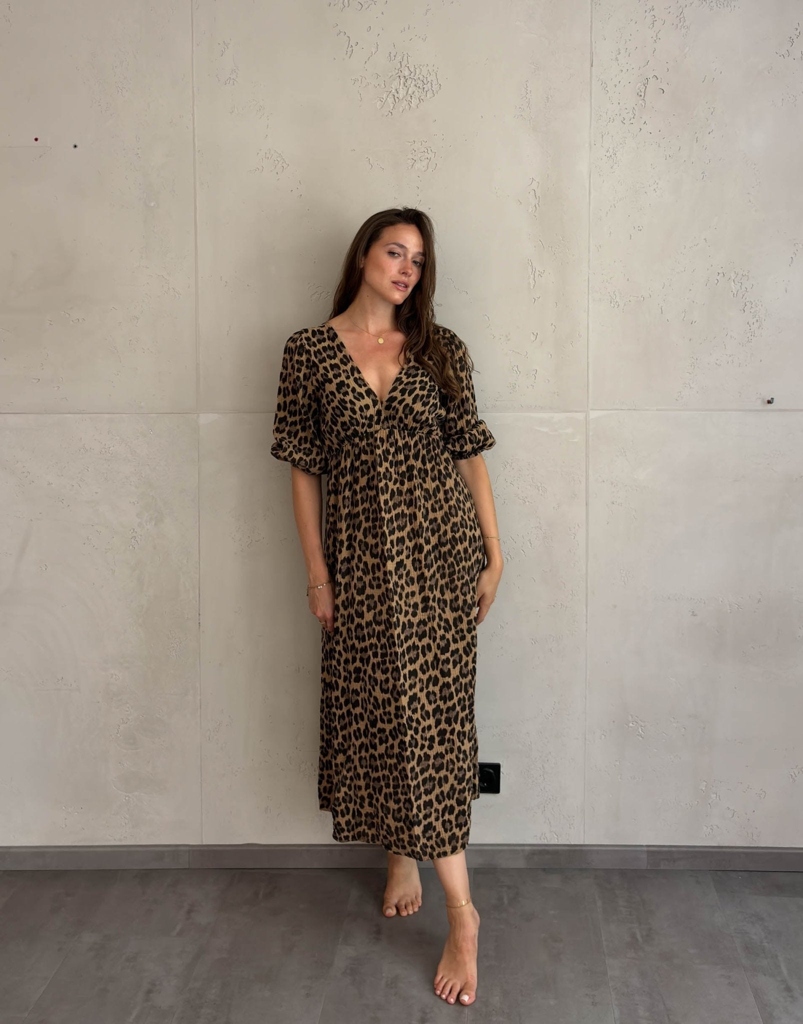 Frau mit braunen Haaren trägt Musselin Leokleid