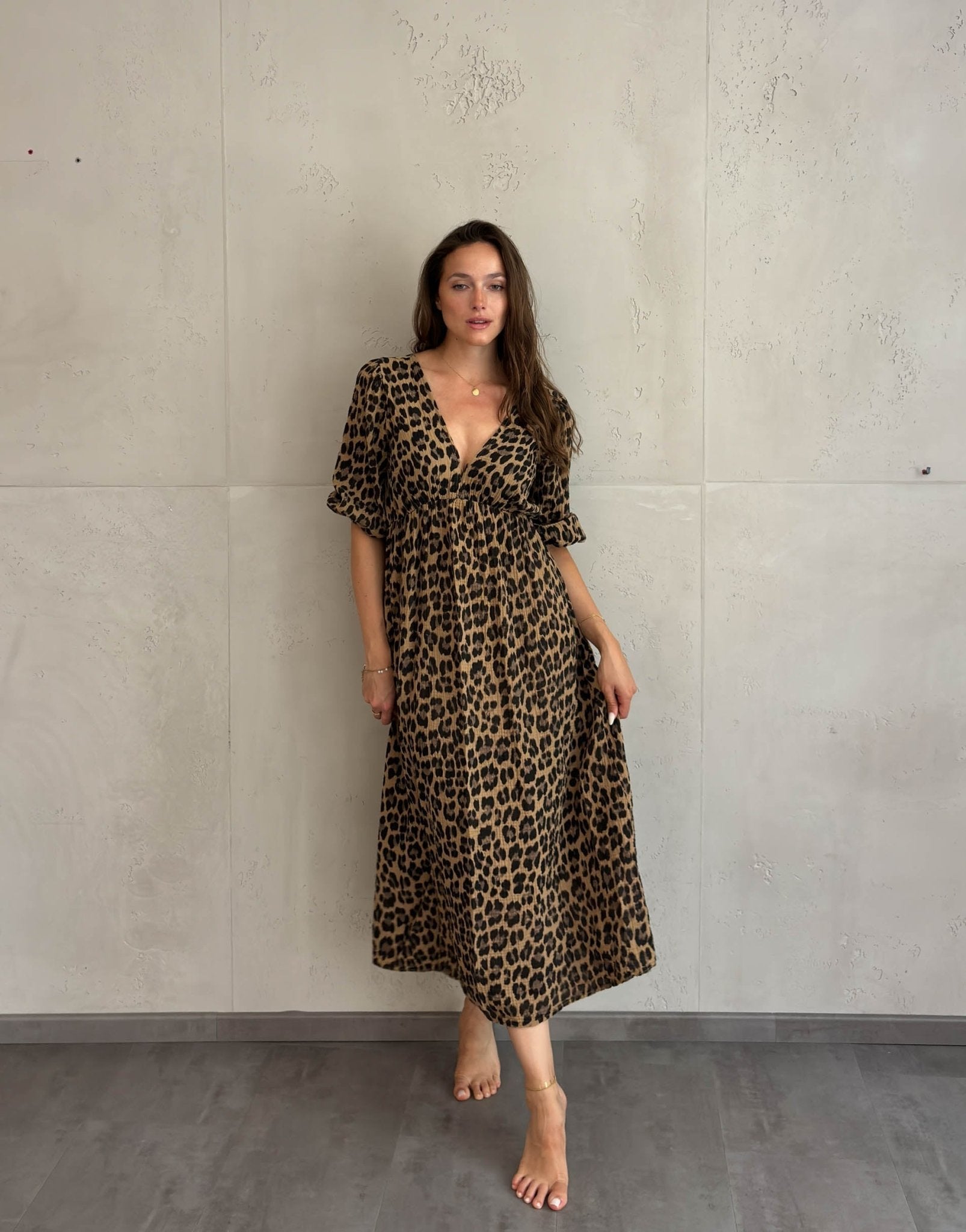 Frau mit braunen Haaren trägt Musselin Leokleid