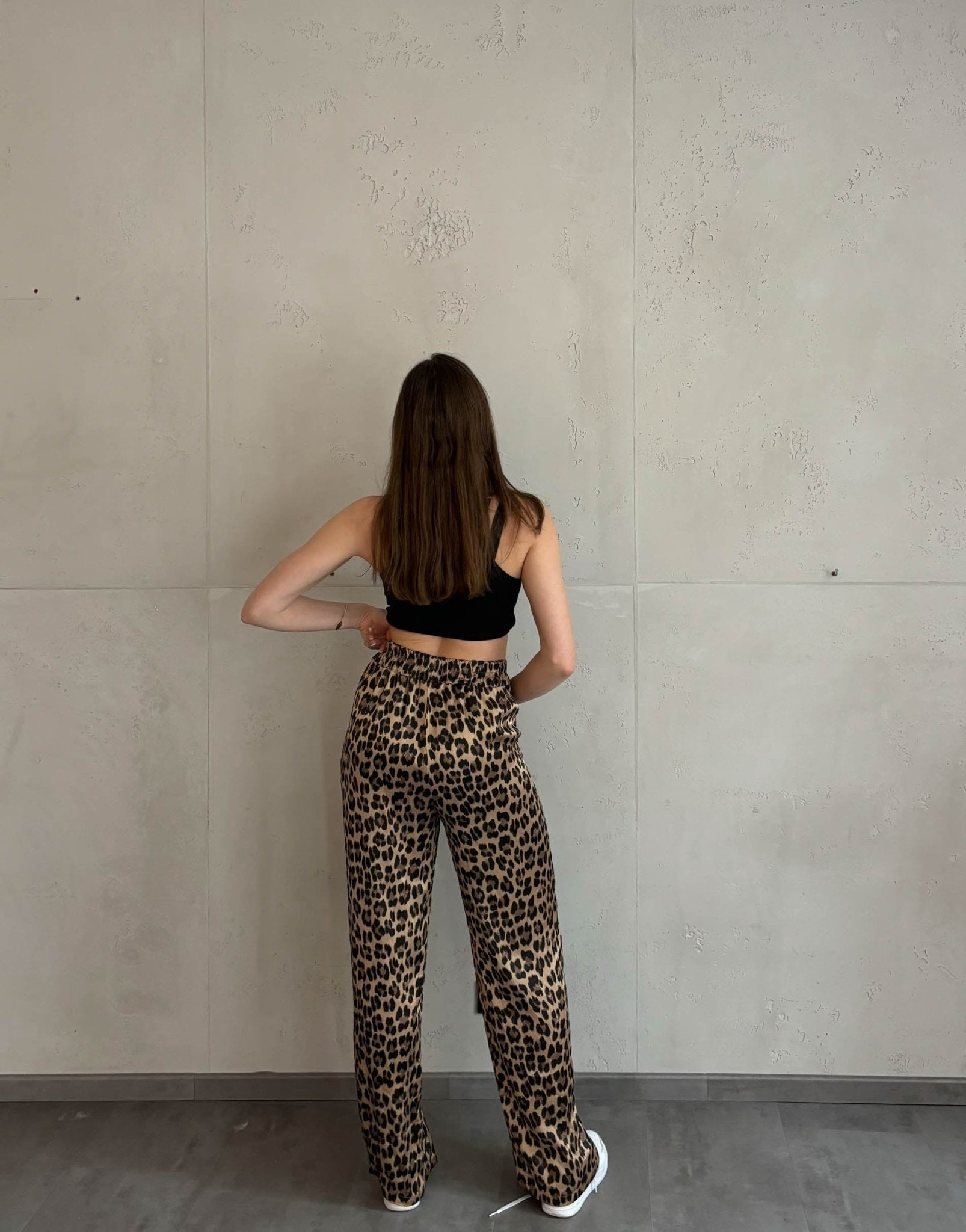 Frau mit braunen Haaren trägt silky Leo hose in gold