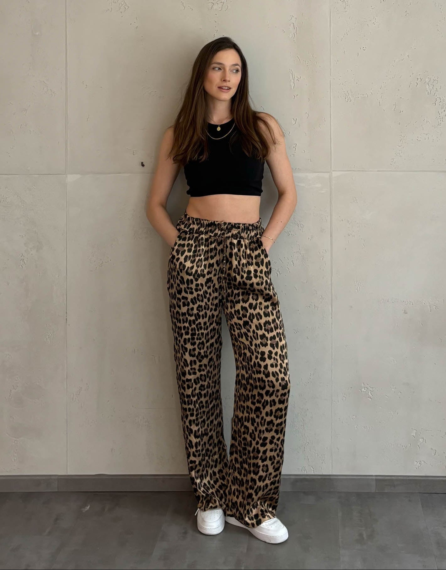 Frau mit braunen Haaren trägt silky Leo hose in gold