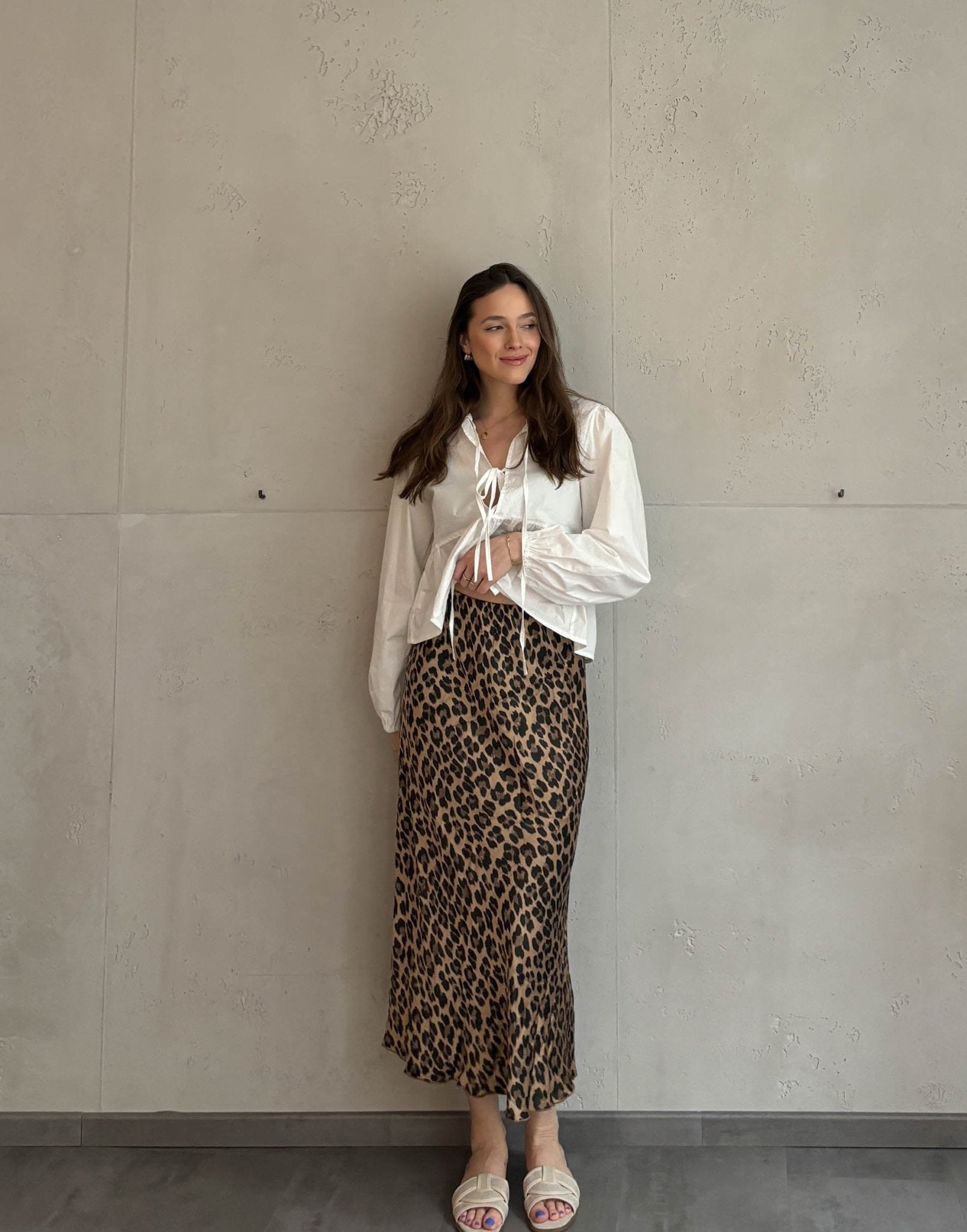 Frau mit brauen Haaren trägt silky Leo Rock in Gold/Braun