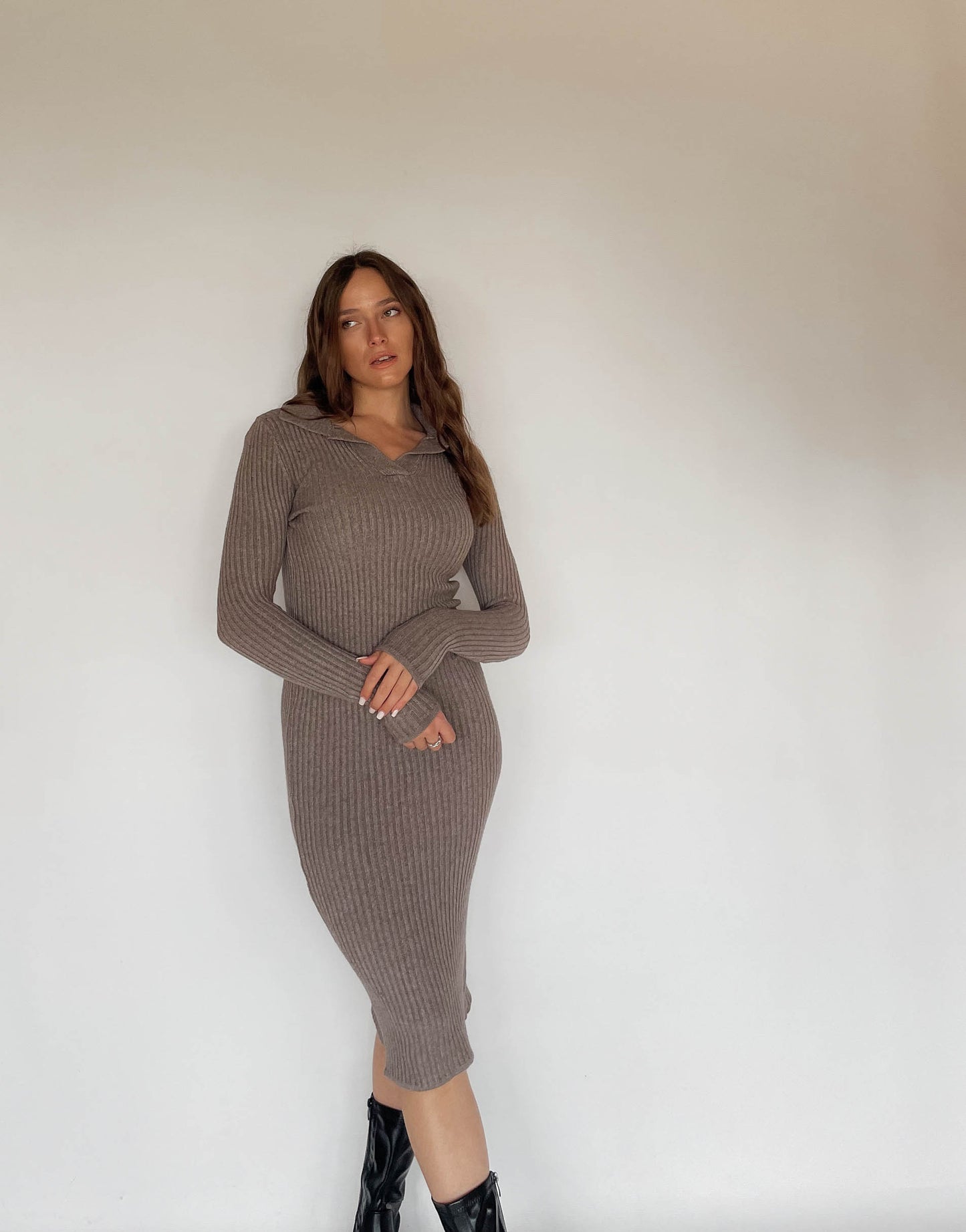 Frau mit brauen Haaren trägt Strickkleid in Taupe