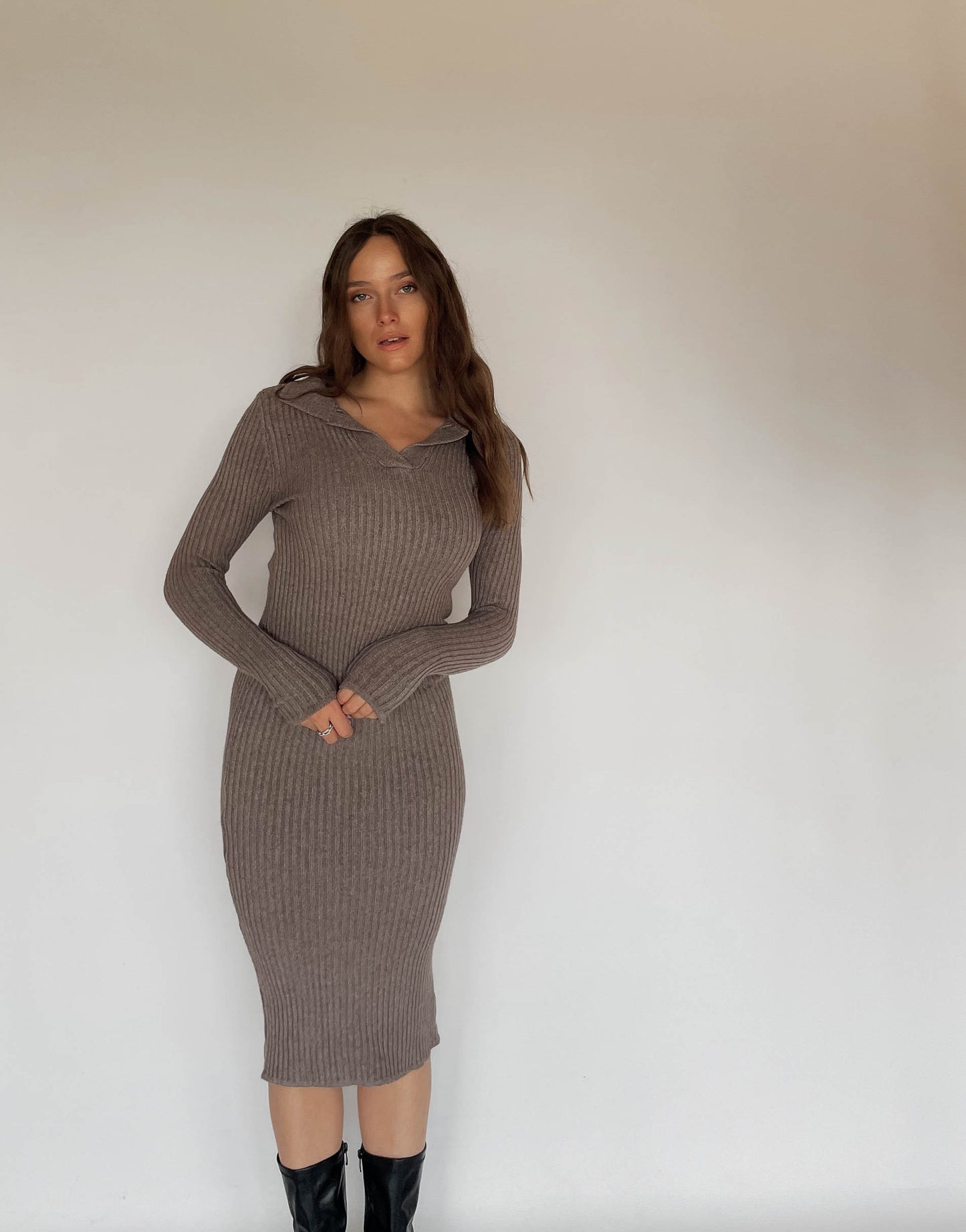 Frau mit brauen Haaren trägt Strickkleid in Taupe