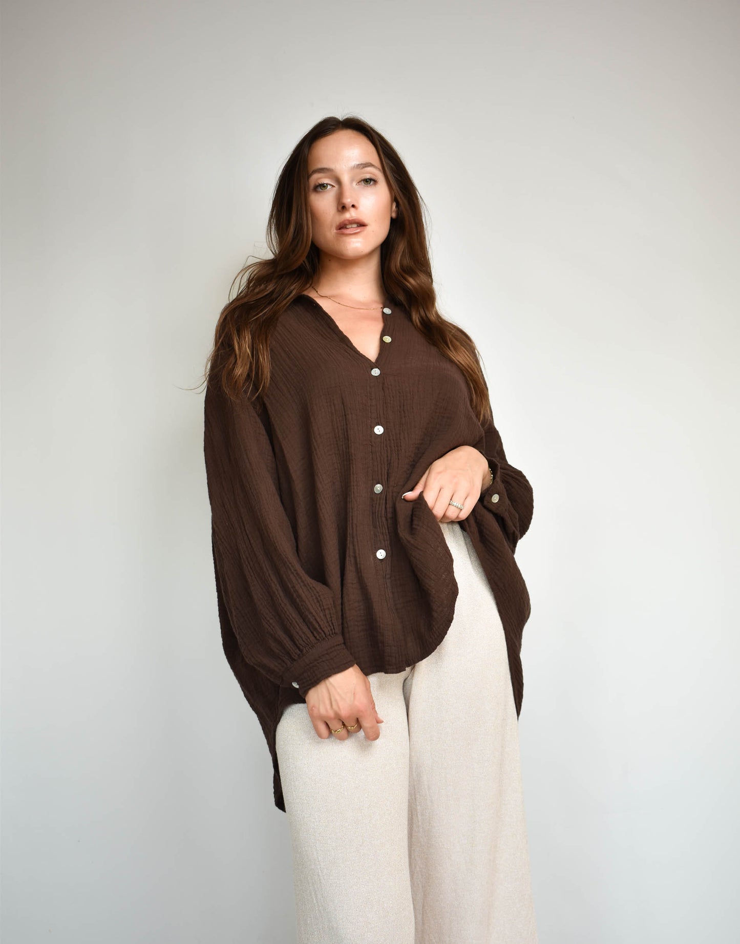 Frau mit brauen Haaren gekleidet in brauner Musselin bluse