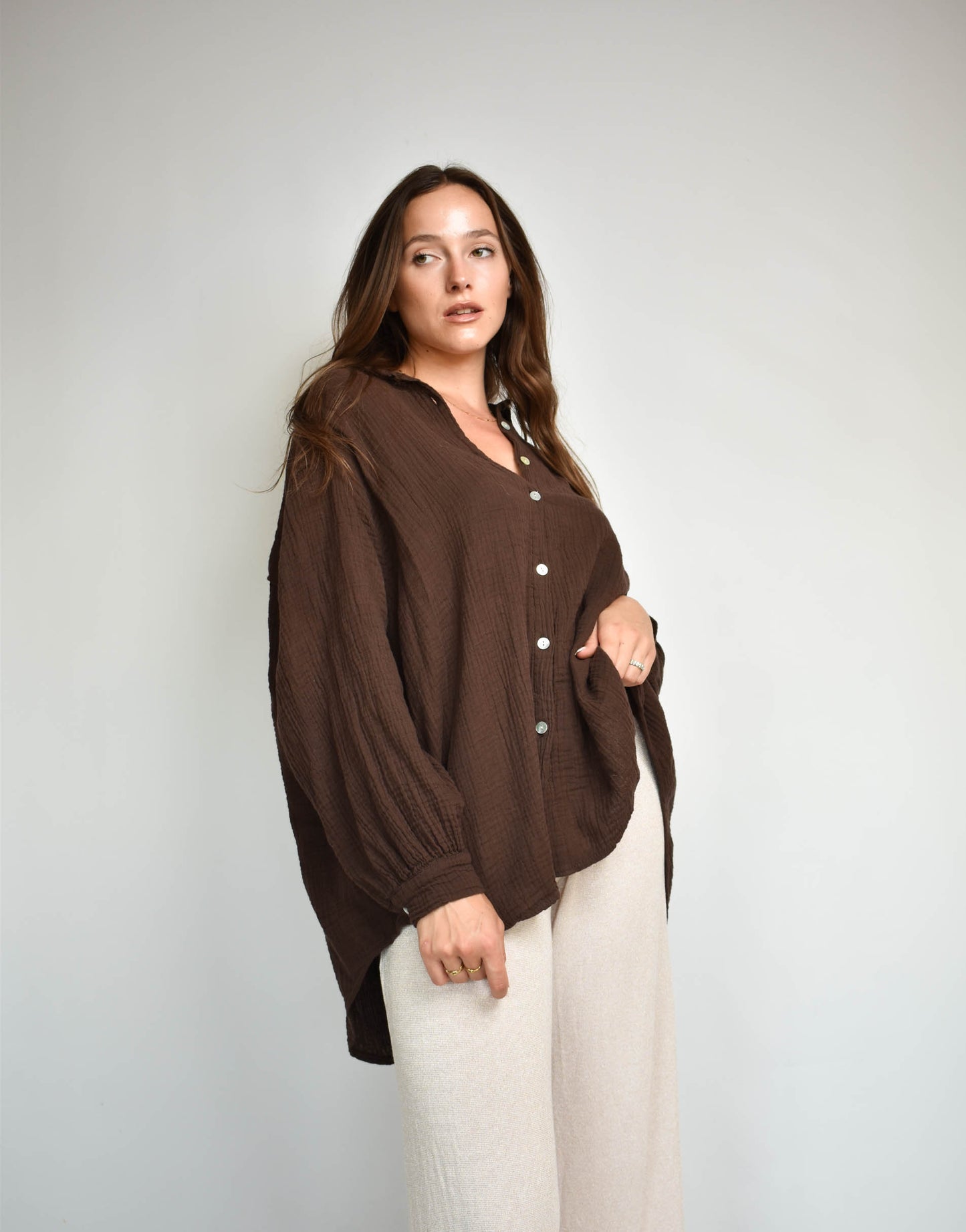 Frau mit brauen Haaren gekleidet in brauen Musselin bluse