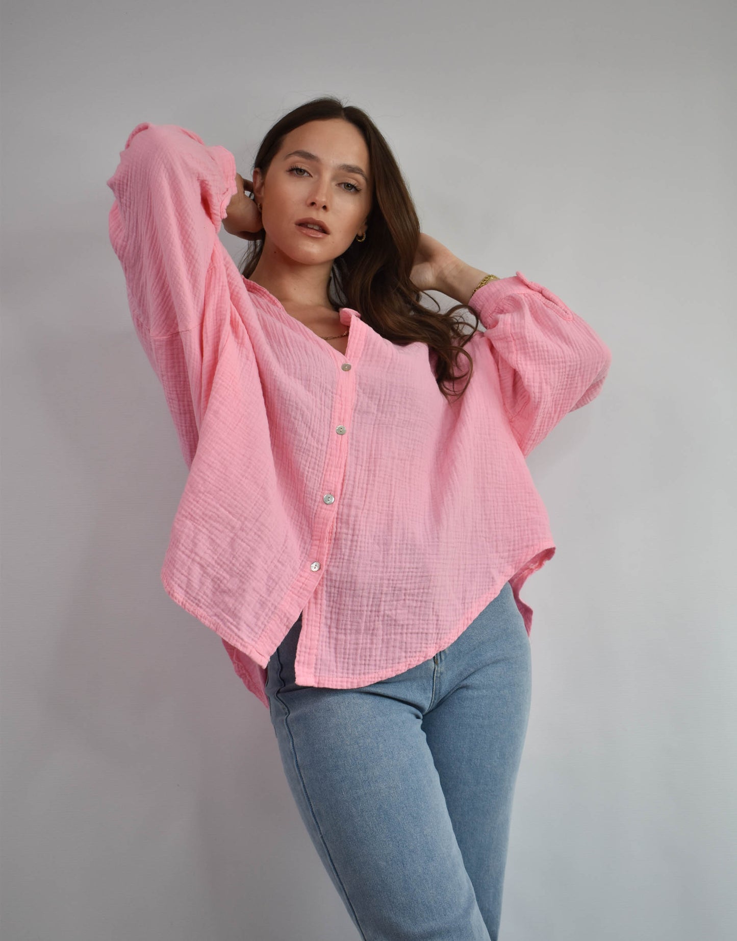 Frau mit brauen Haaren gekleidet in rosa Musselin bluse