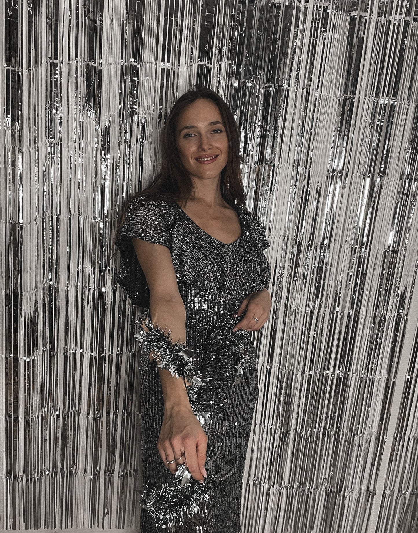 Frau mit brauen Haaren trägt Midi Glitzerkleid