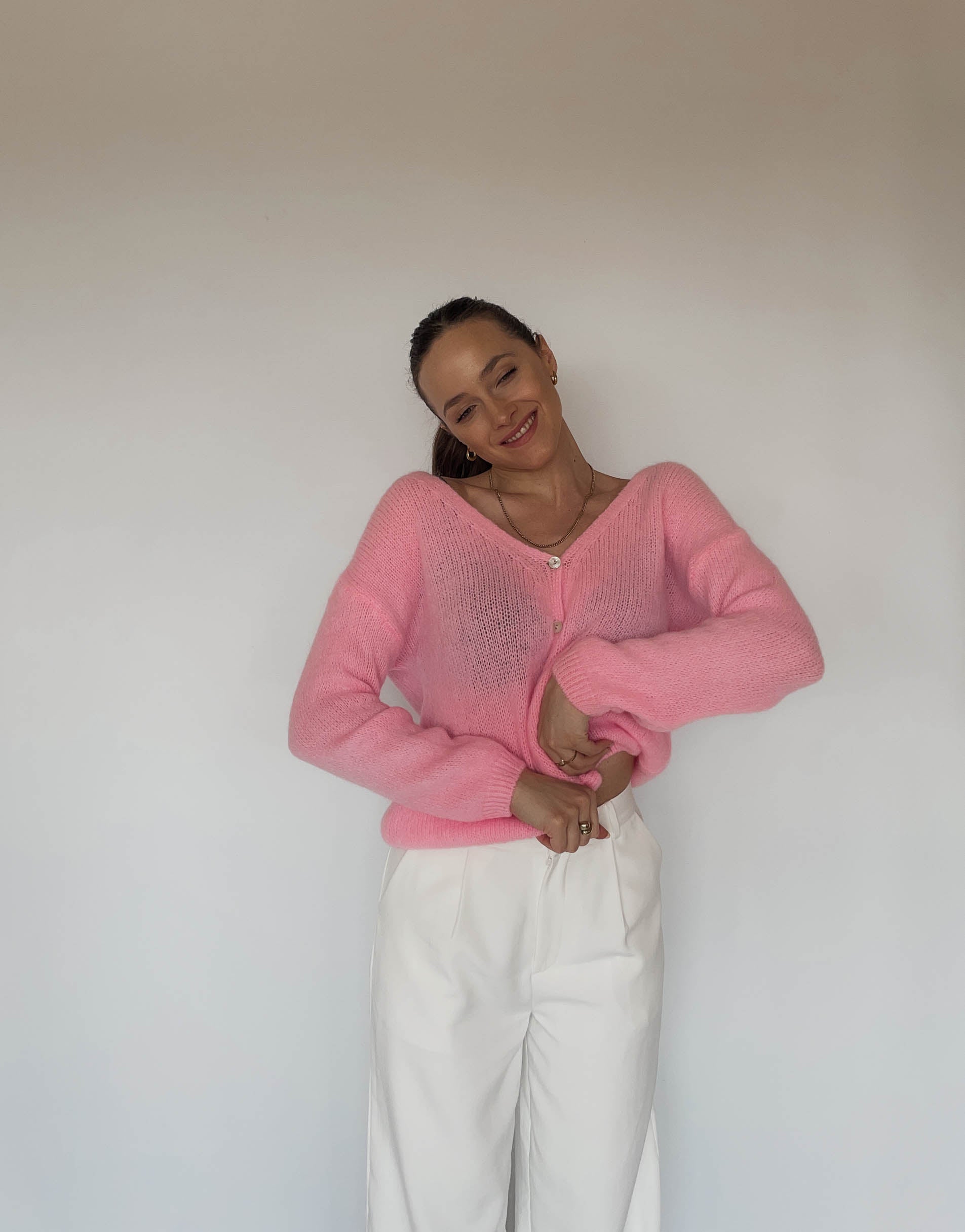 Frau mit brauen Haaren trägt kurze Mohair Strickjacke