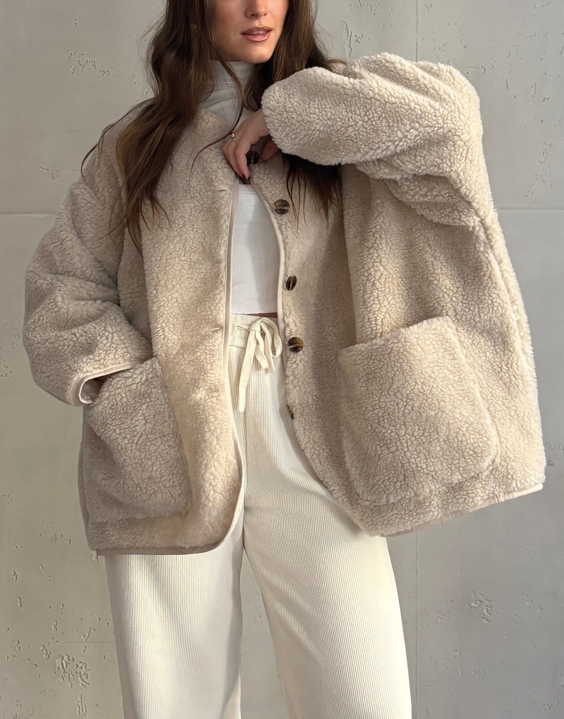 Frau mit brauen Haaren trägt Trenchcoat in beige