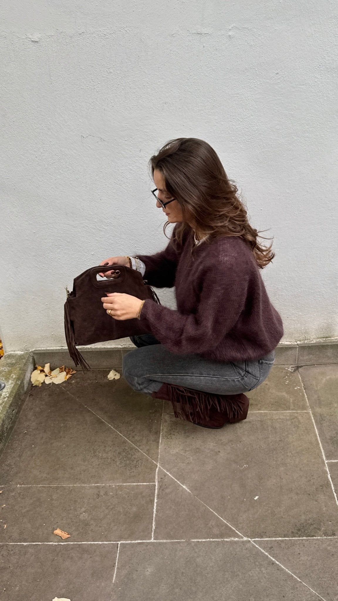 Frau mit brauen Haaren trägt Hoodie mit Aufschrift in grau