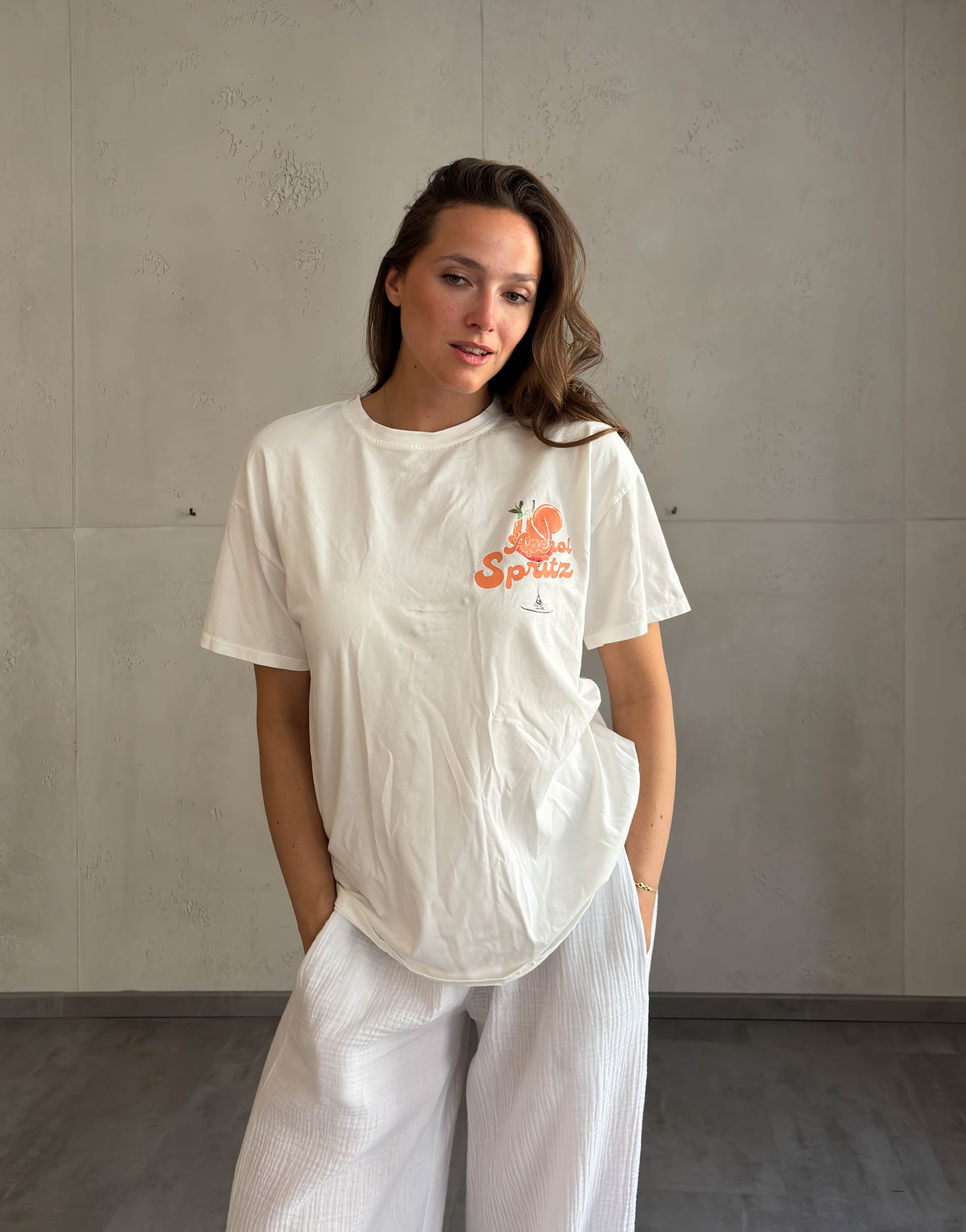 Frau mit braunen Haaren trägt Aperol Spritz T-Shirt 