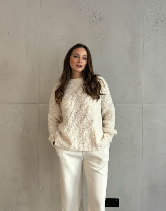 Frau mit braunen Haaren trägt oversize Boucle Pullover in beige 