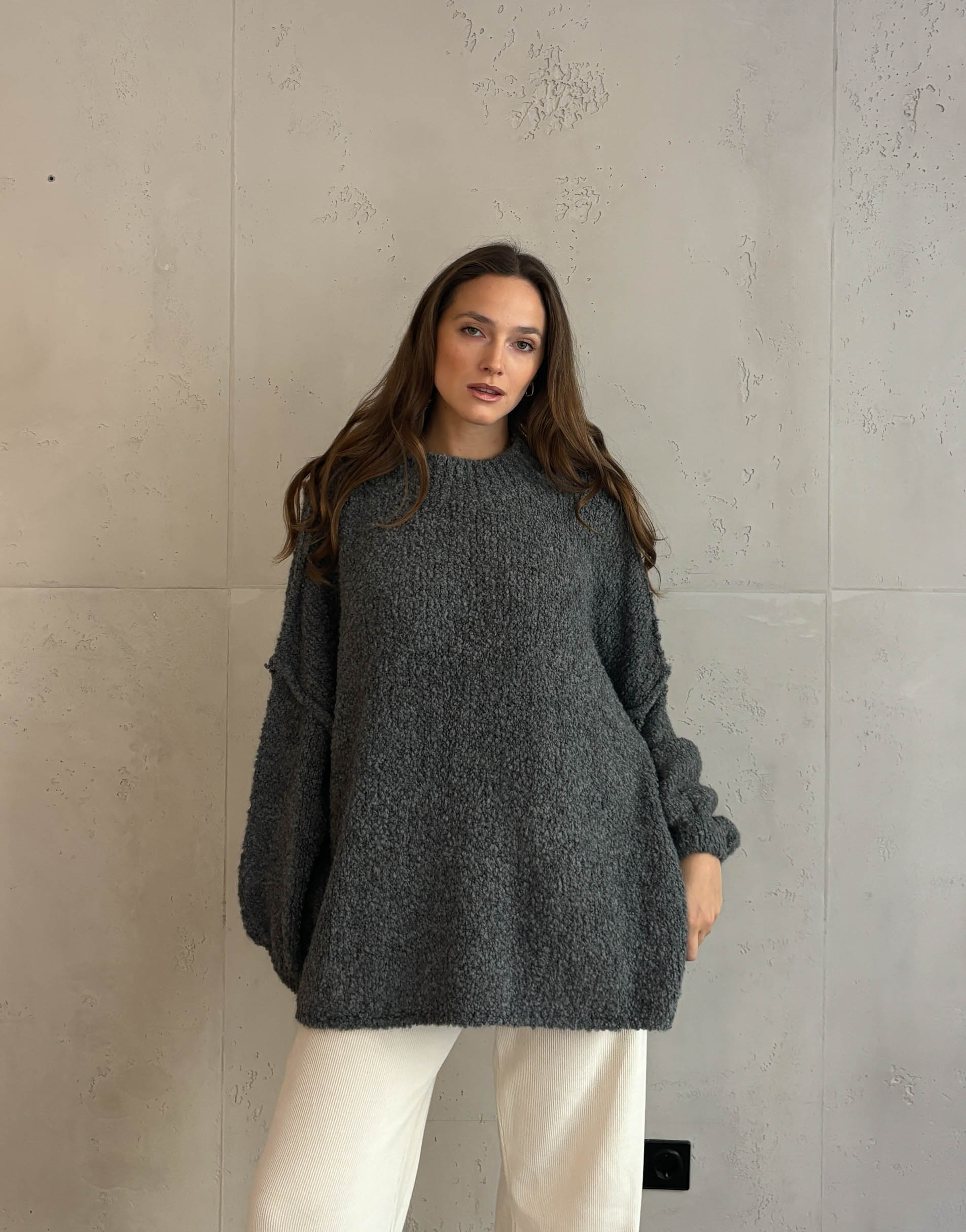 Frau mit braunen haaren trägt Oversize Stehkragen Pullover in Boucle 