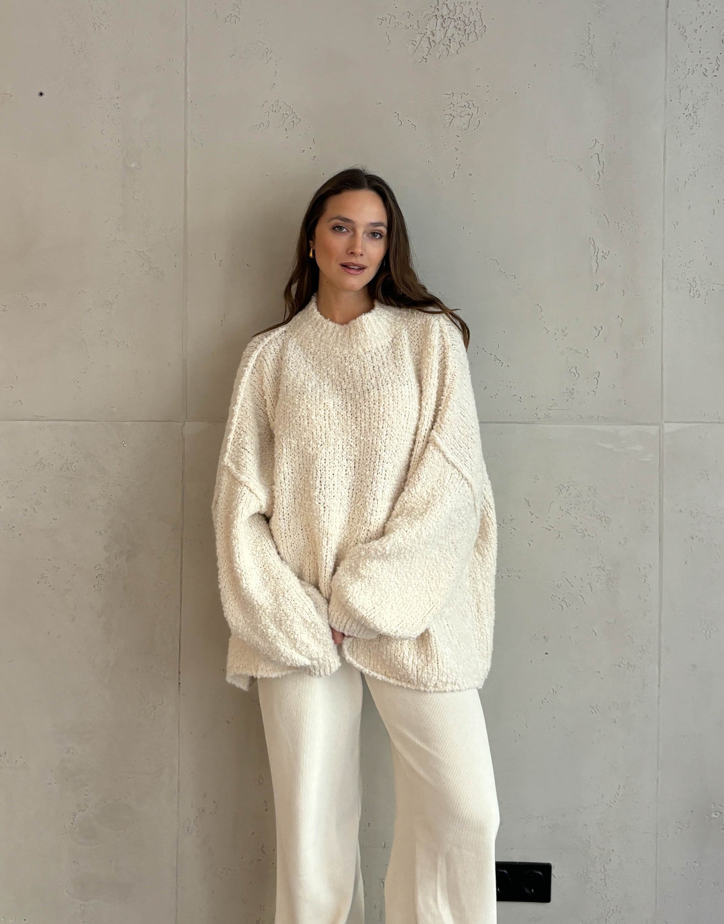 Frau mit braunen haaren trägt Oversize Stehkragen Pullover in Boucle 