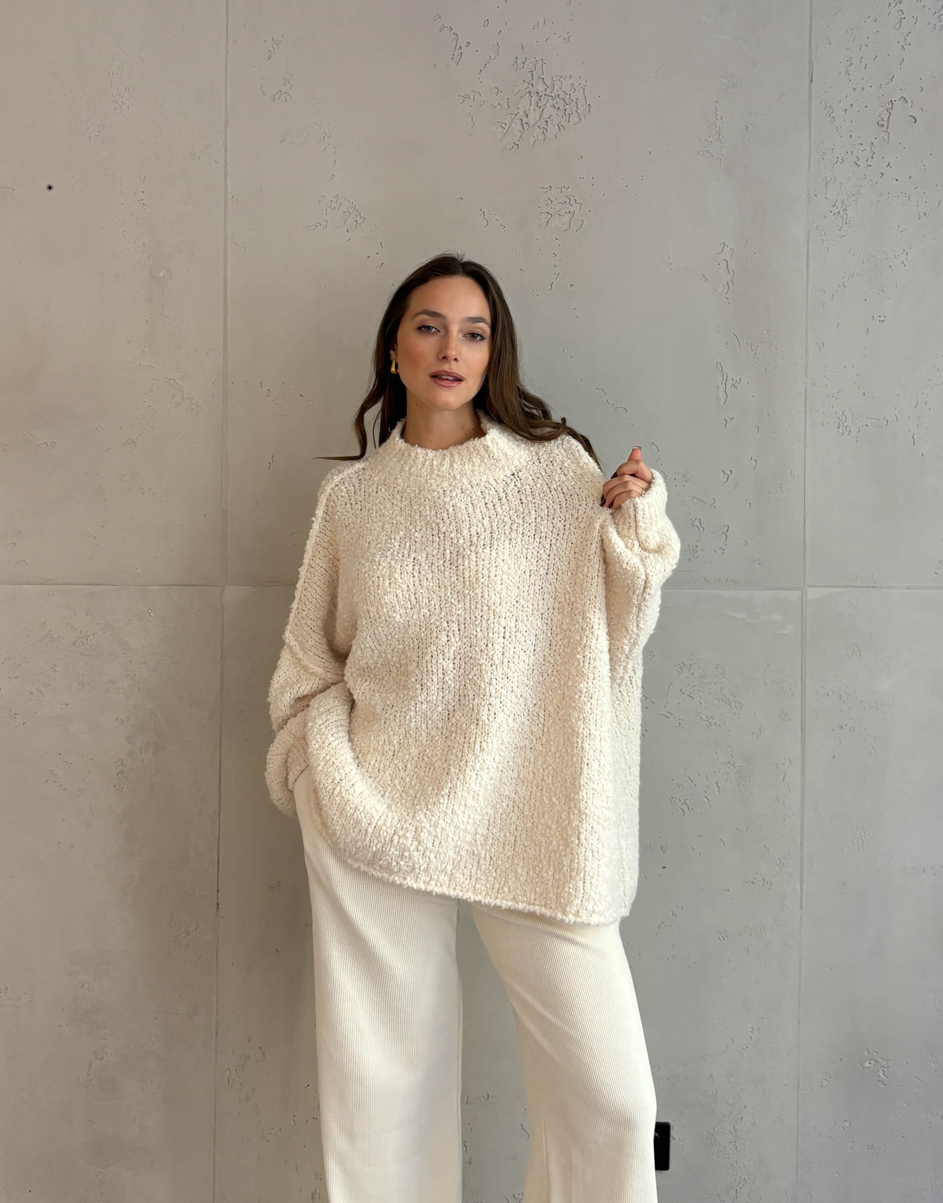 Frau mit braunen haaren trägt Oversize Stehkragen Pullover in Boucle 