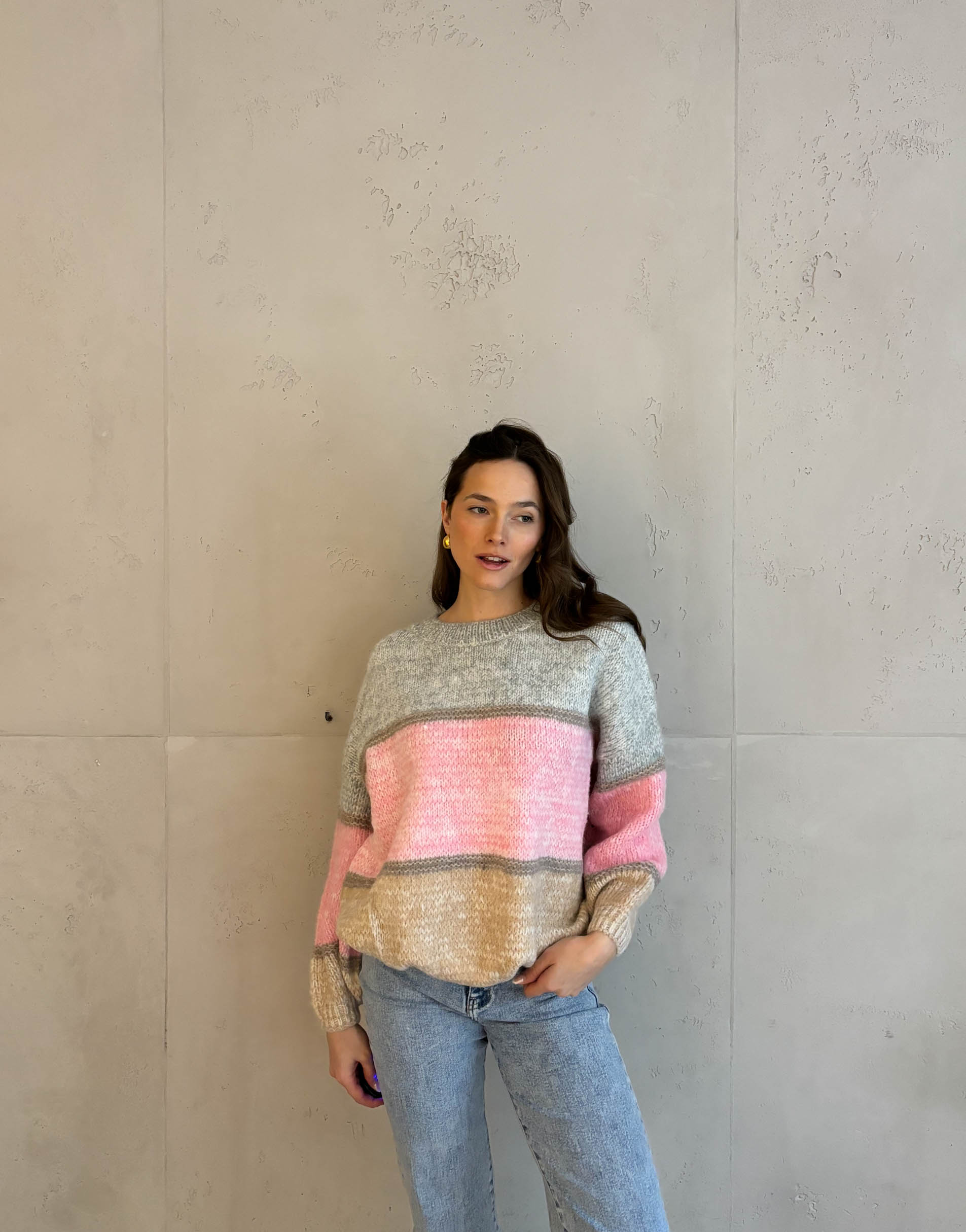 Frau mit brauen Haaren trägt Pullover in Colorblocking Design
