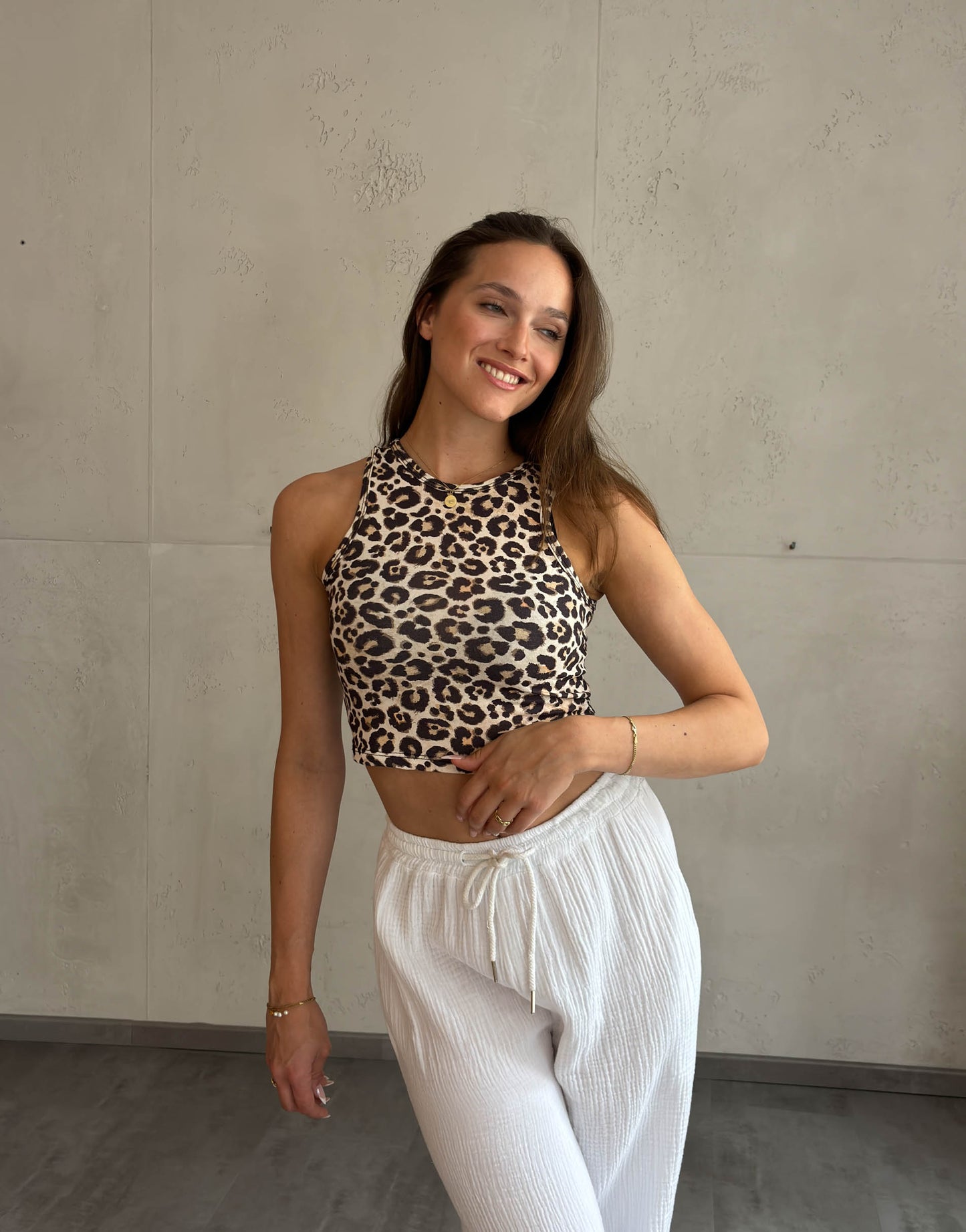 Frau mit braunen Haaren trägt crop top mit Leo Print 