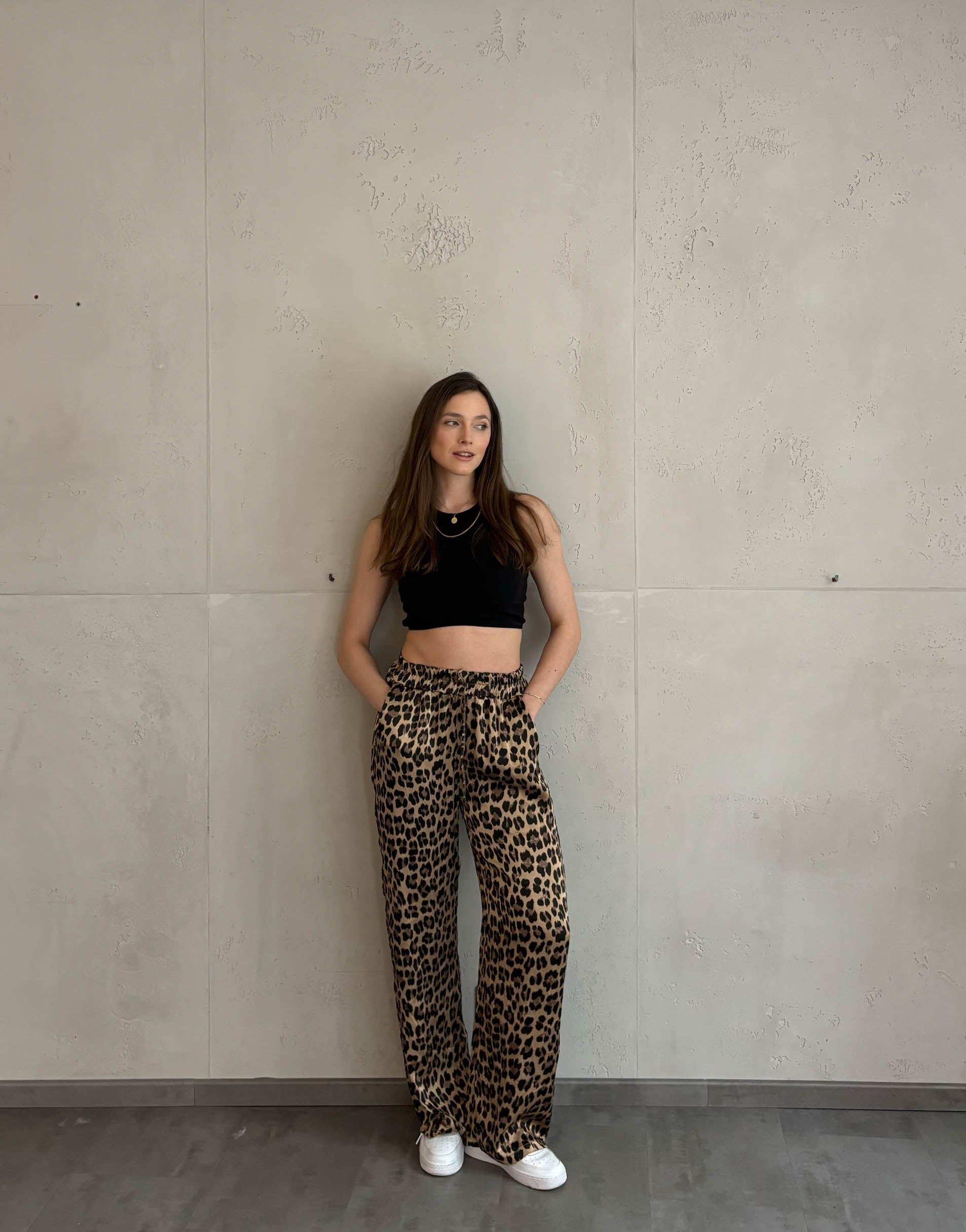 Frau mit braunen Haaren trägt silky Leo hose in gold 
