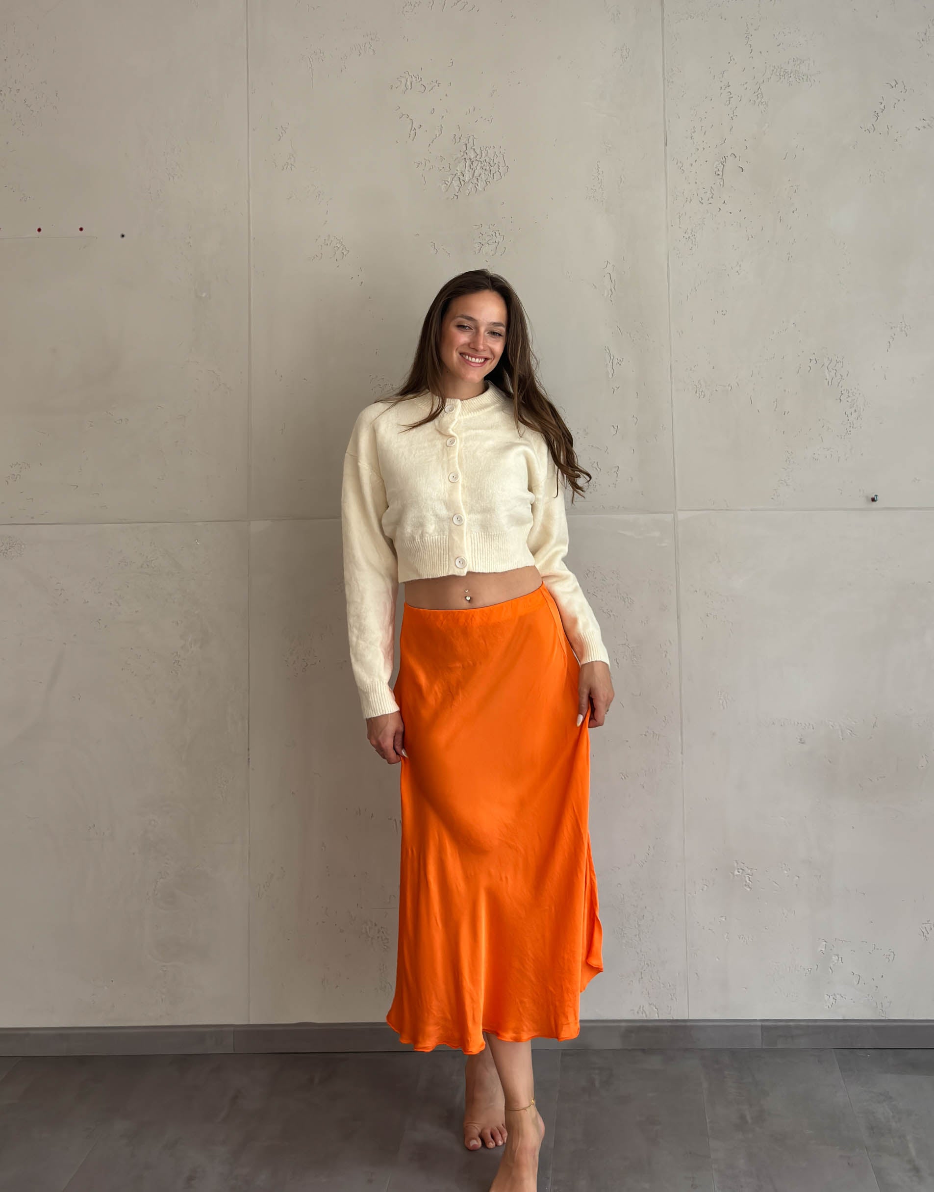 Frau mit braunen Haaren trägt Midi Silky Rock in Orange