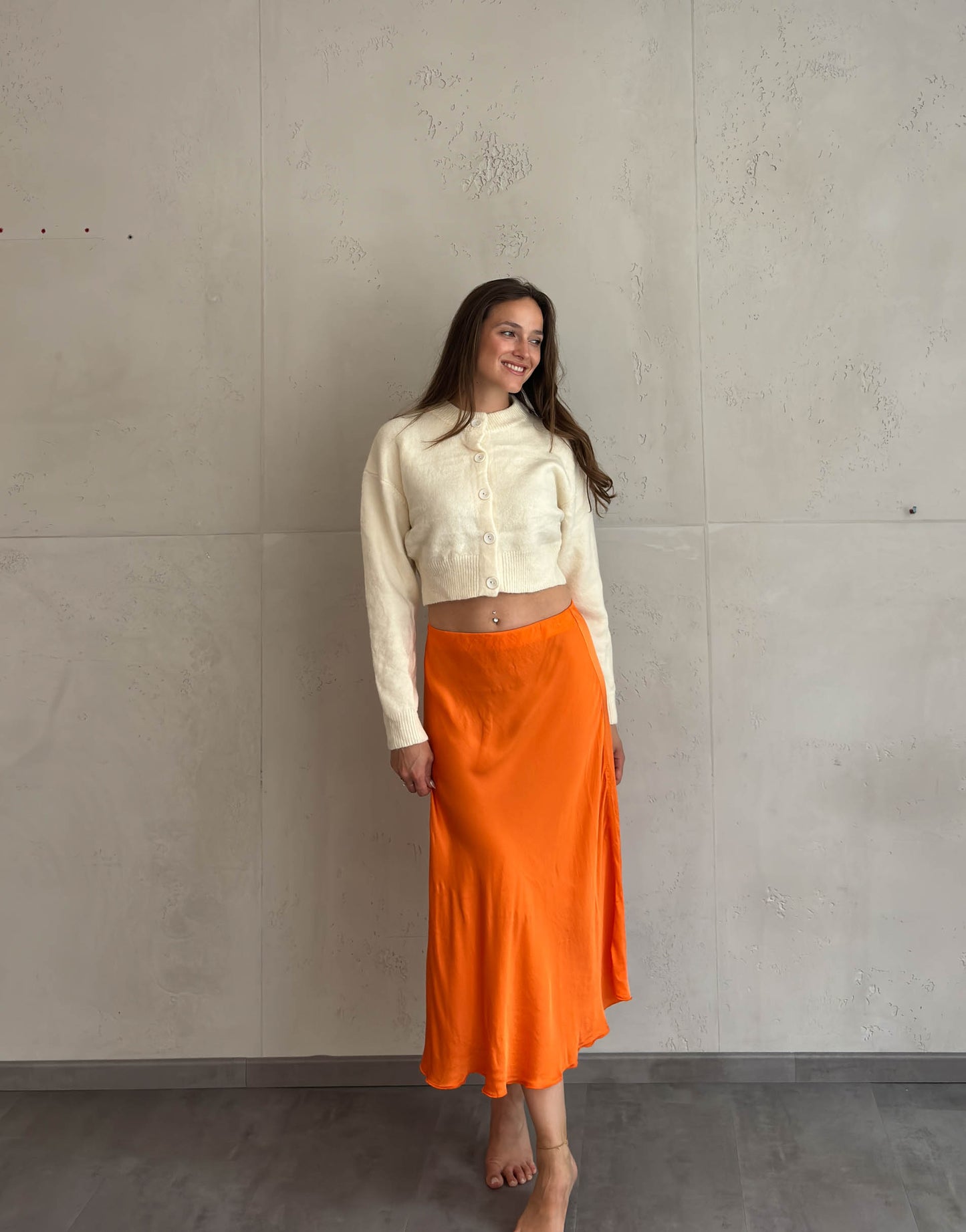 Frau mit braunen Haaren trägt Midi Silky Rock in Orange