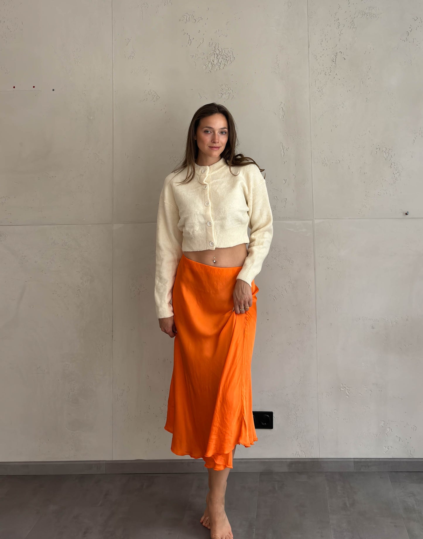 Frau mit braunen Haaren trägt Midi Silky Rock in Orange