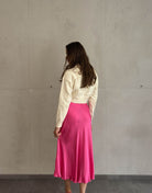 Frau mit braunen Haaren trägt Midi Silky Rock in Pink