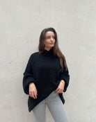 Frau mit brauen Haaren trägt oversize Pullover in Schwarz