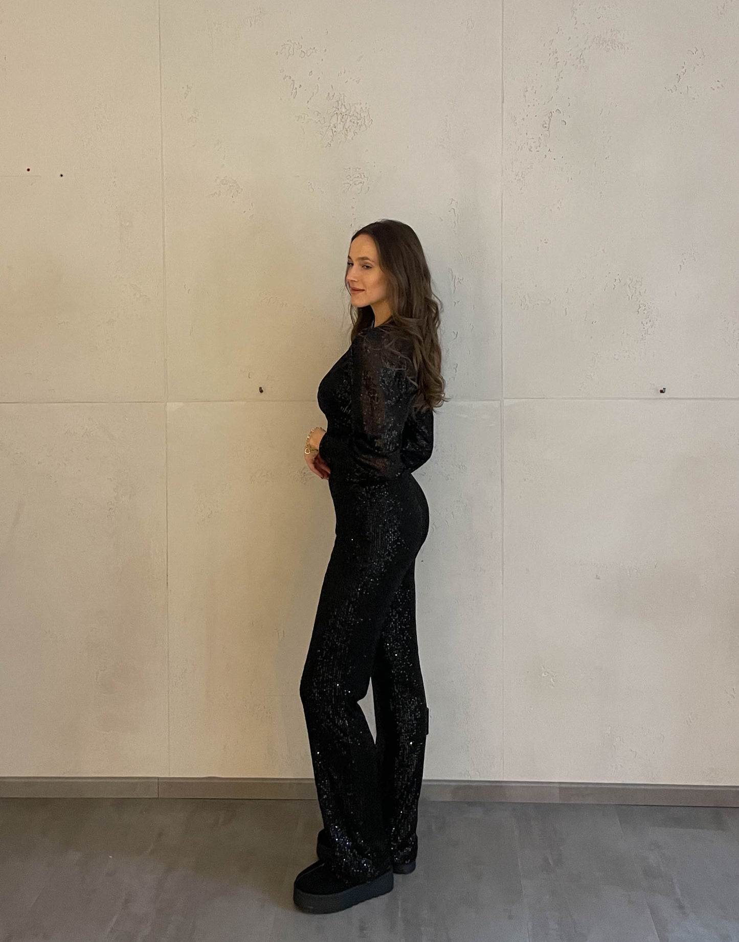 Frau mit brauen Haaren trägt Paillettenhose in schwarz