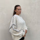 Frau mit brauen Haaren trägt Oversize Pullover in Wollweiß