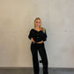 Frau mit blonden Haaren trägt Samt Paillettenhose in Schwarz