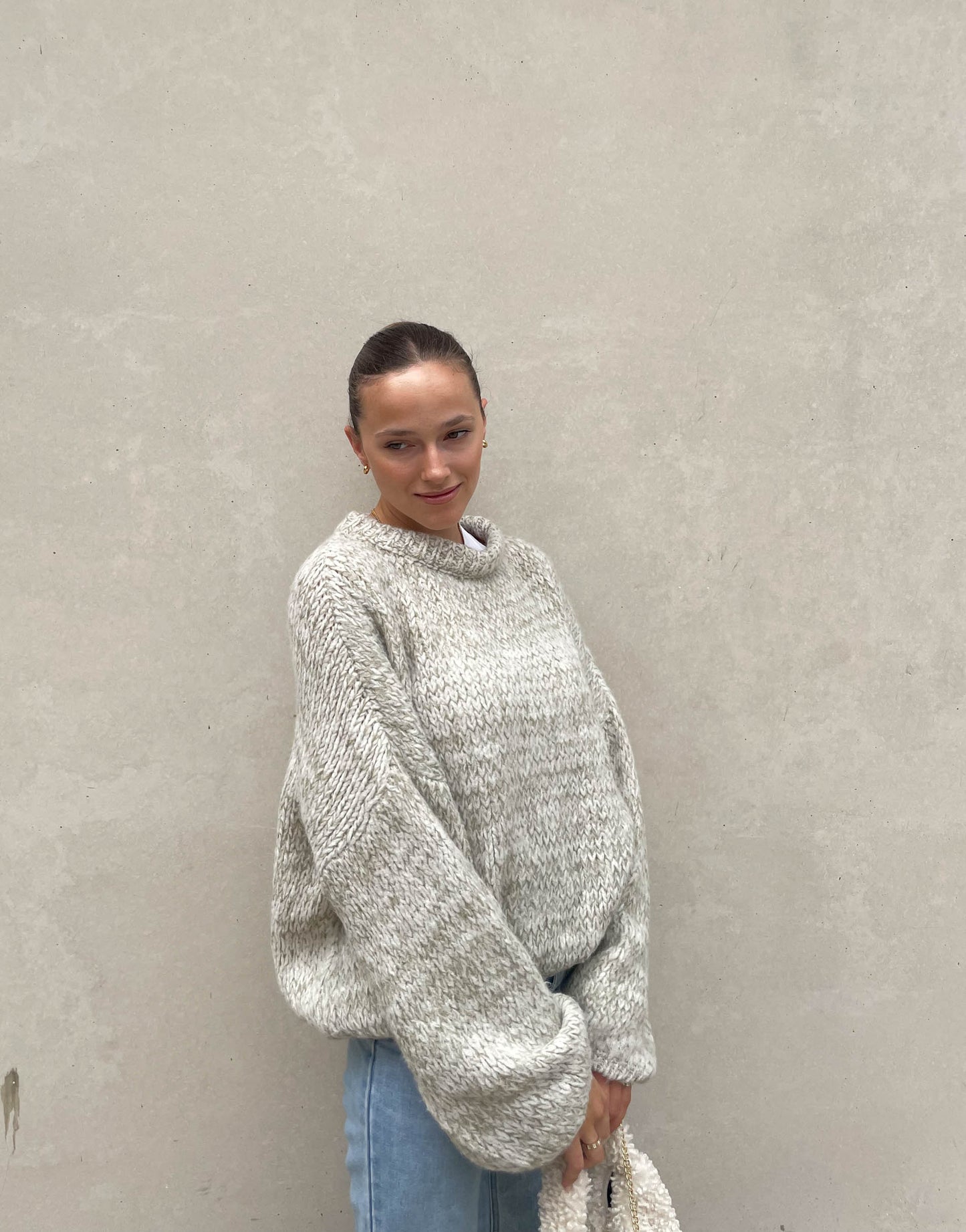 Frau mit brauen Haaren trägt Strickpullover in Mint