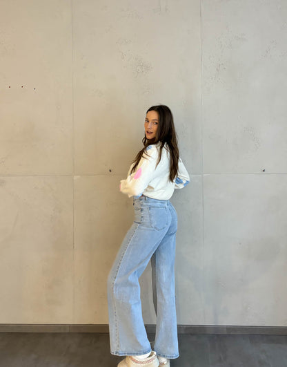 Frau mit brauen Haaren trägt wide leg Jeans