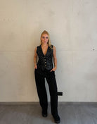 Frau mit blonden Haaren trägt Anzughose in Schwarz