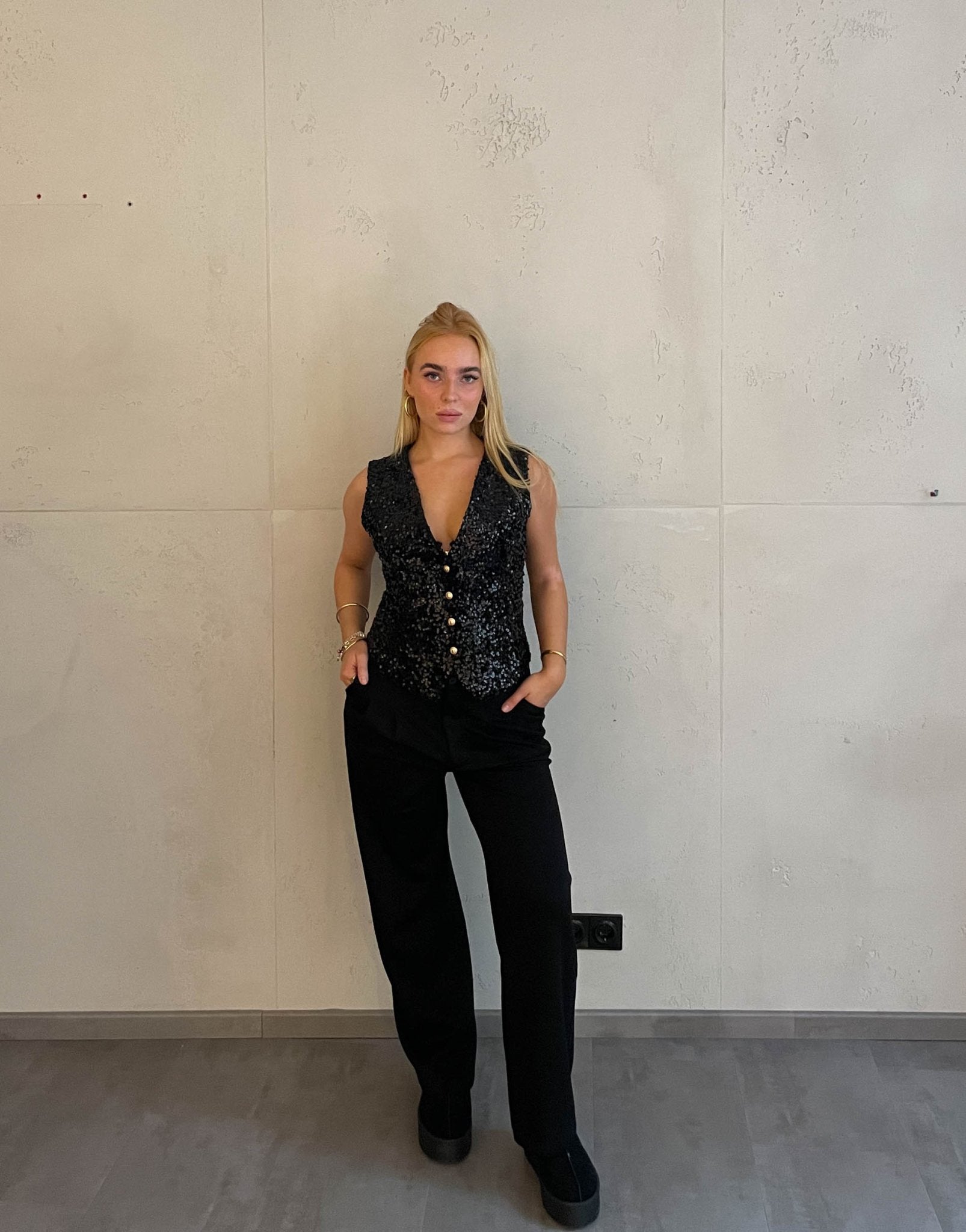 Frau mit blonden Haaren trägt Anzughose in Schwarz