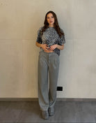 Frau mit braunen Haaren trägt Anzughose in Grau