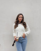 Frau mit brauen Haaren trägt kurze Mohair Strickjacke in Wollweiß