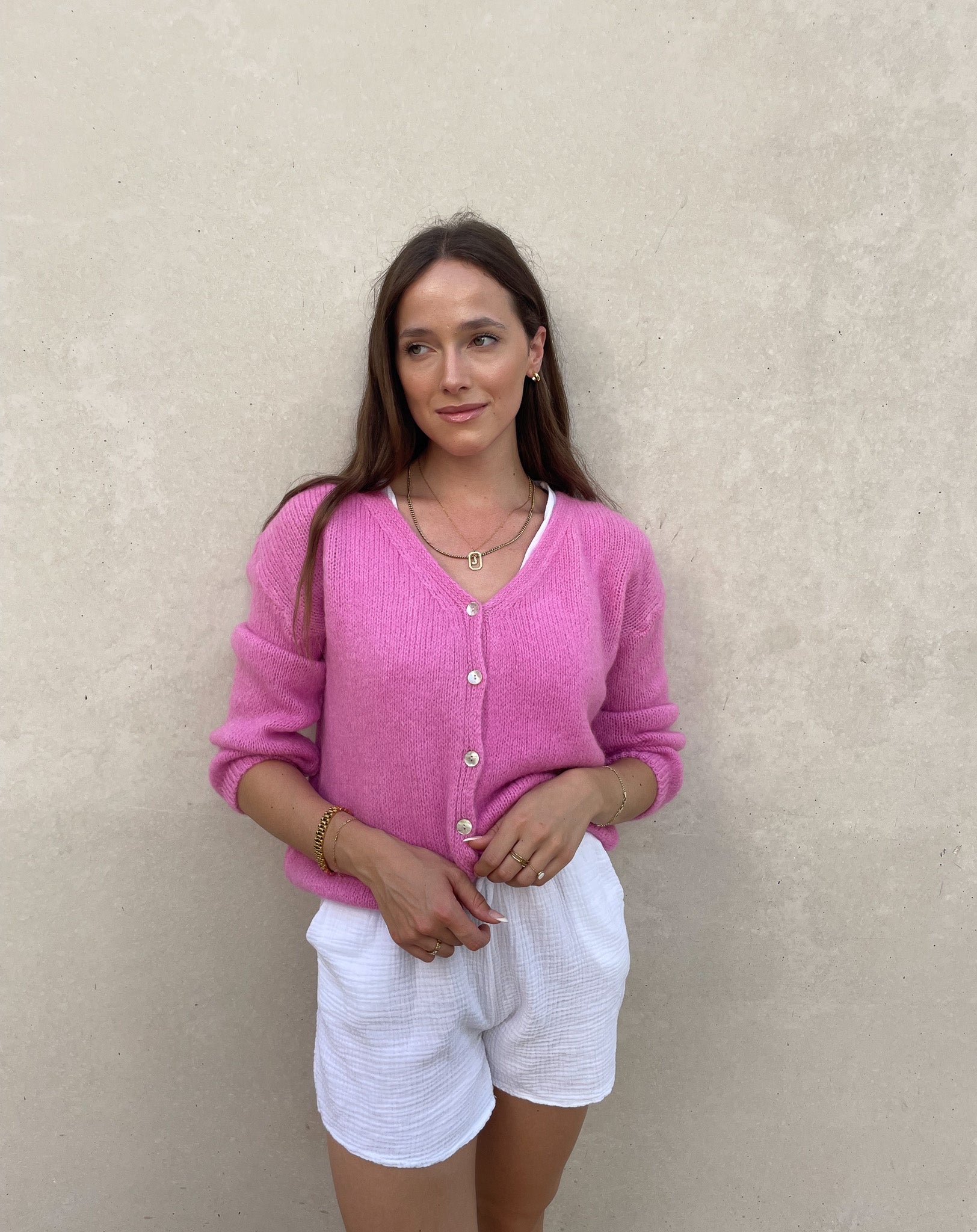 Frau mit brauen Haaren trägt kurze Mohair Strickjacke in Pink