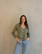 Frau mit brauen Haaren trägt kurze Mohair Strickjacke in Pistazie