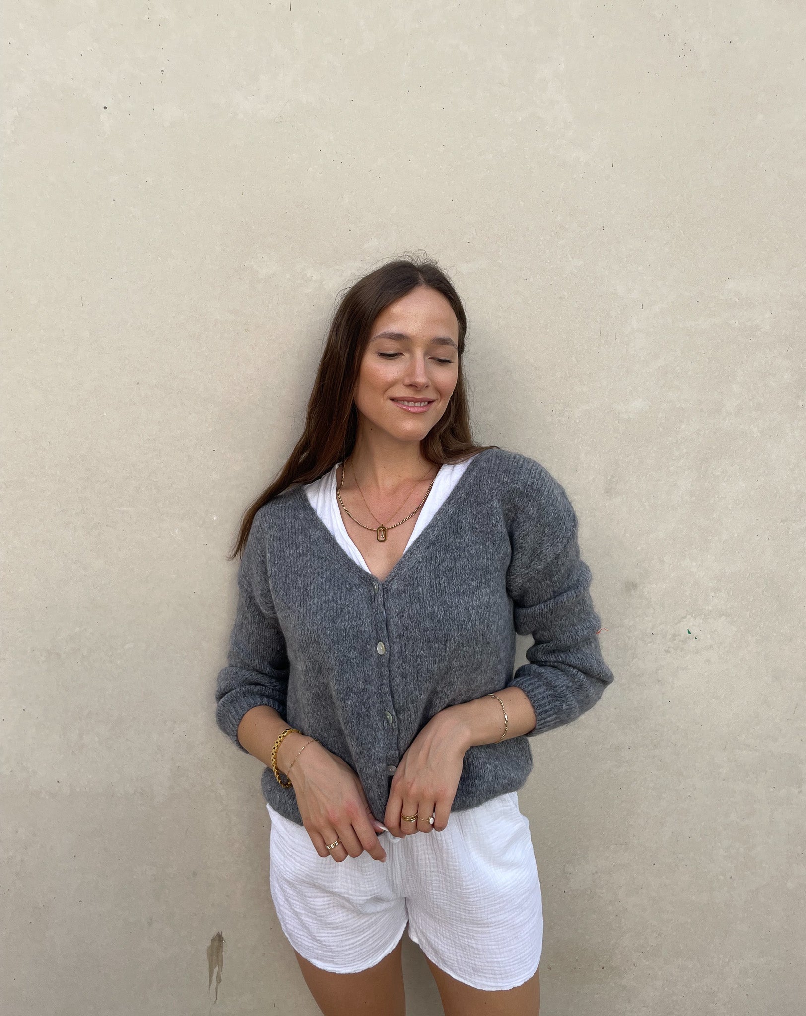 Frau mit brauen Haaren trägt kurze Mohair Strickjacke in dunkelgrau