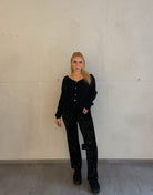 Frau mit brauen Haaren trägt kurze Mohair Strickjacke in schwarz